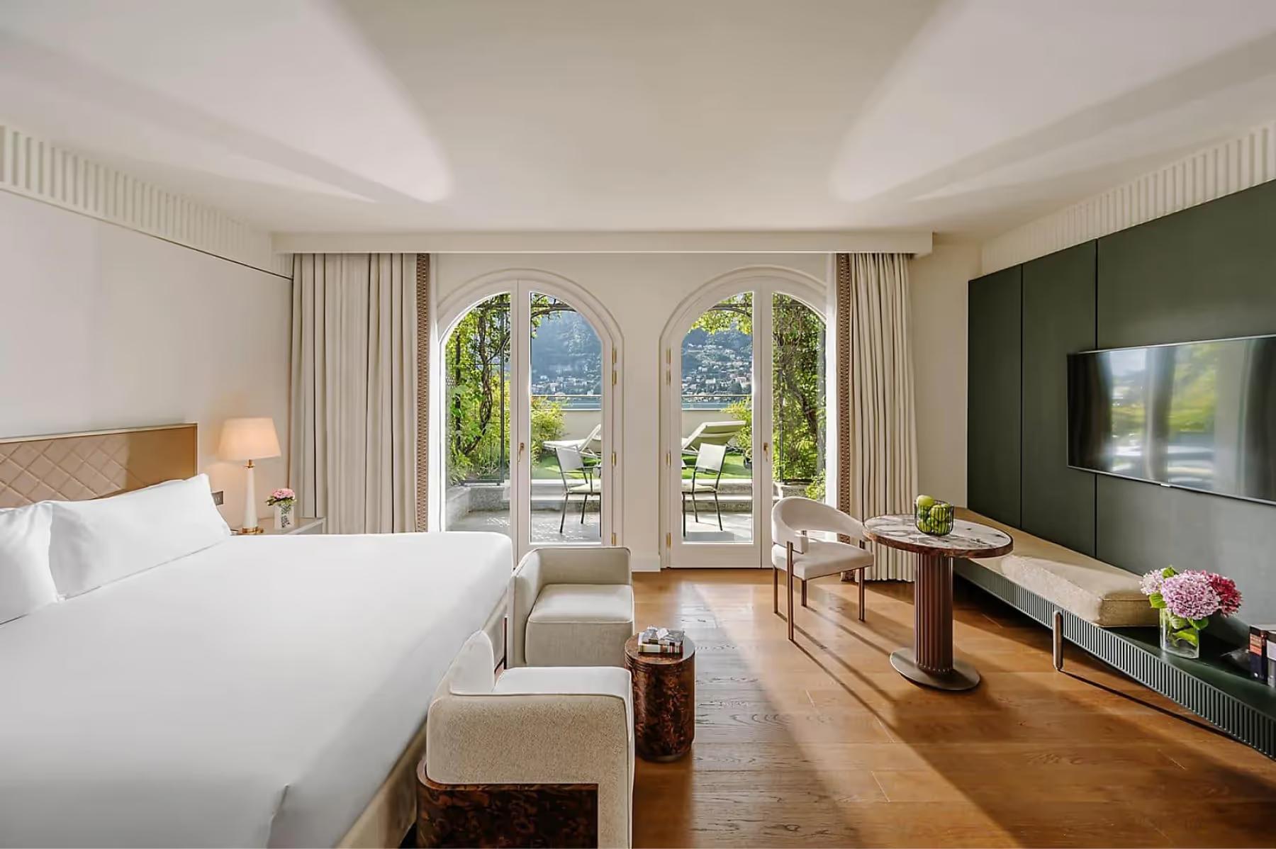 Mandarin Oriental, Lake Como: spacious bedroom with white linens and views across French doors to mountains and lake