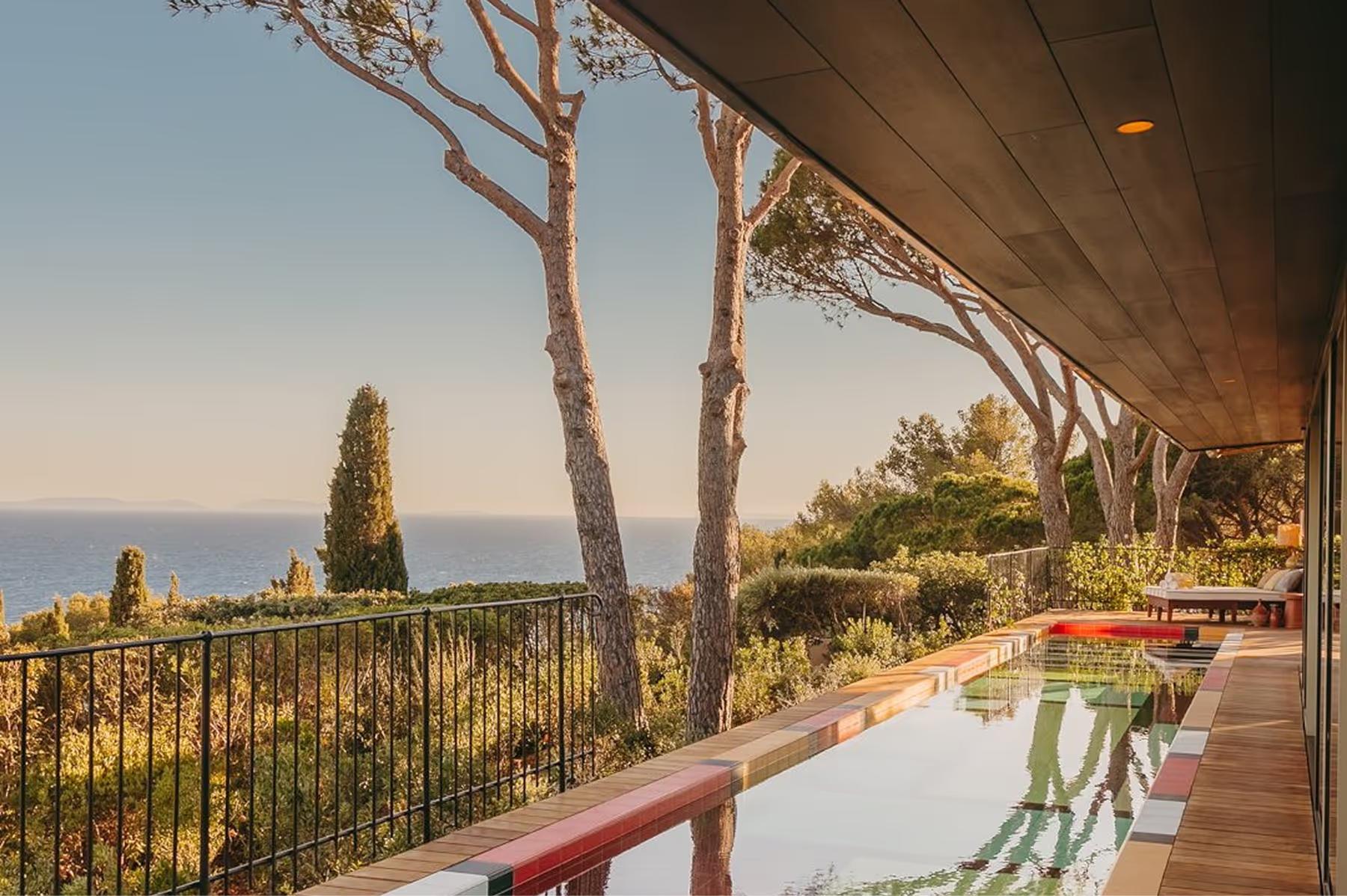 Lily of the Valley: wooden terrace beneath pine trees with Mediterranean sea view at dawn