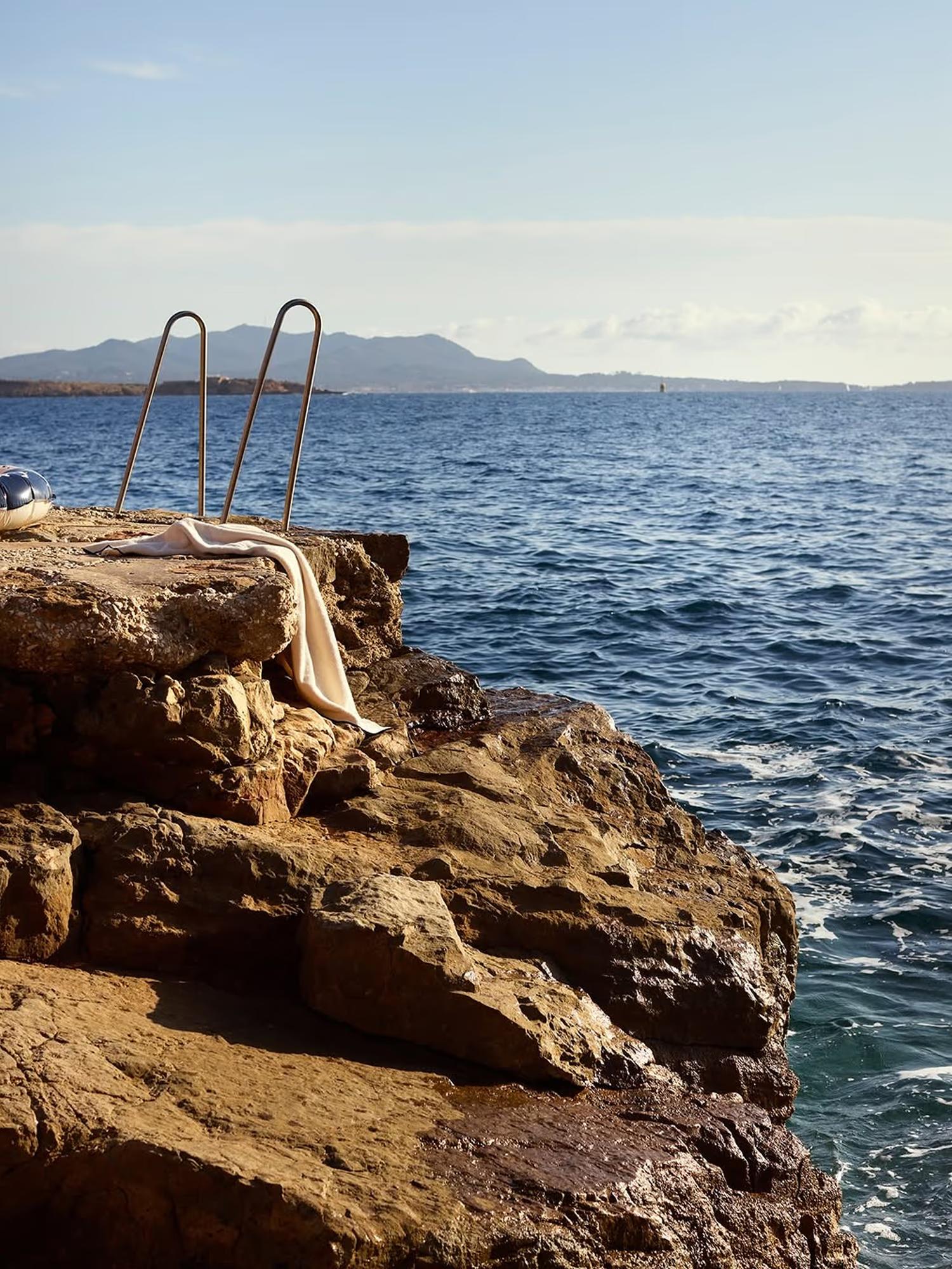 A swim ladder on a rocky Mediterranean point, open sea beyond