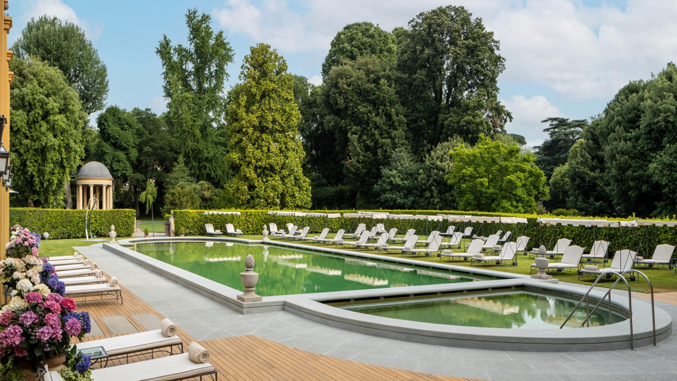Four Seasons Hotel Firenze: resort pool surrounded by manicured gardens with geometric hedgerow patterns and mature shade trees