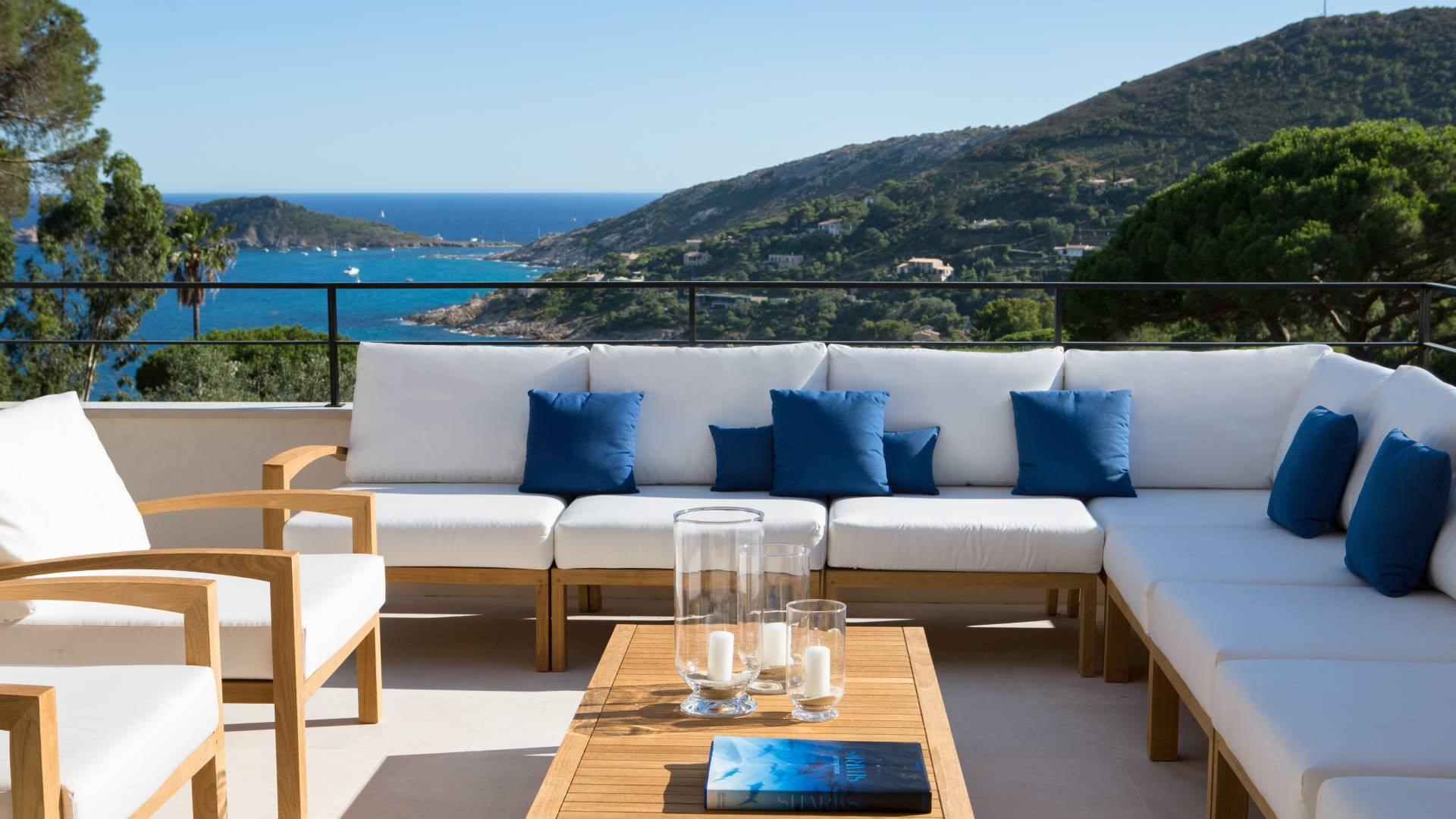 La Réserve Ramatuelle: terraced oceanside seating with cream cushions and blue throw pillows