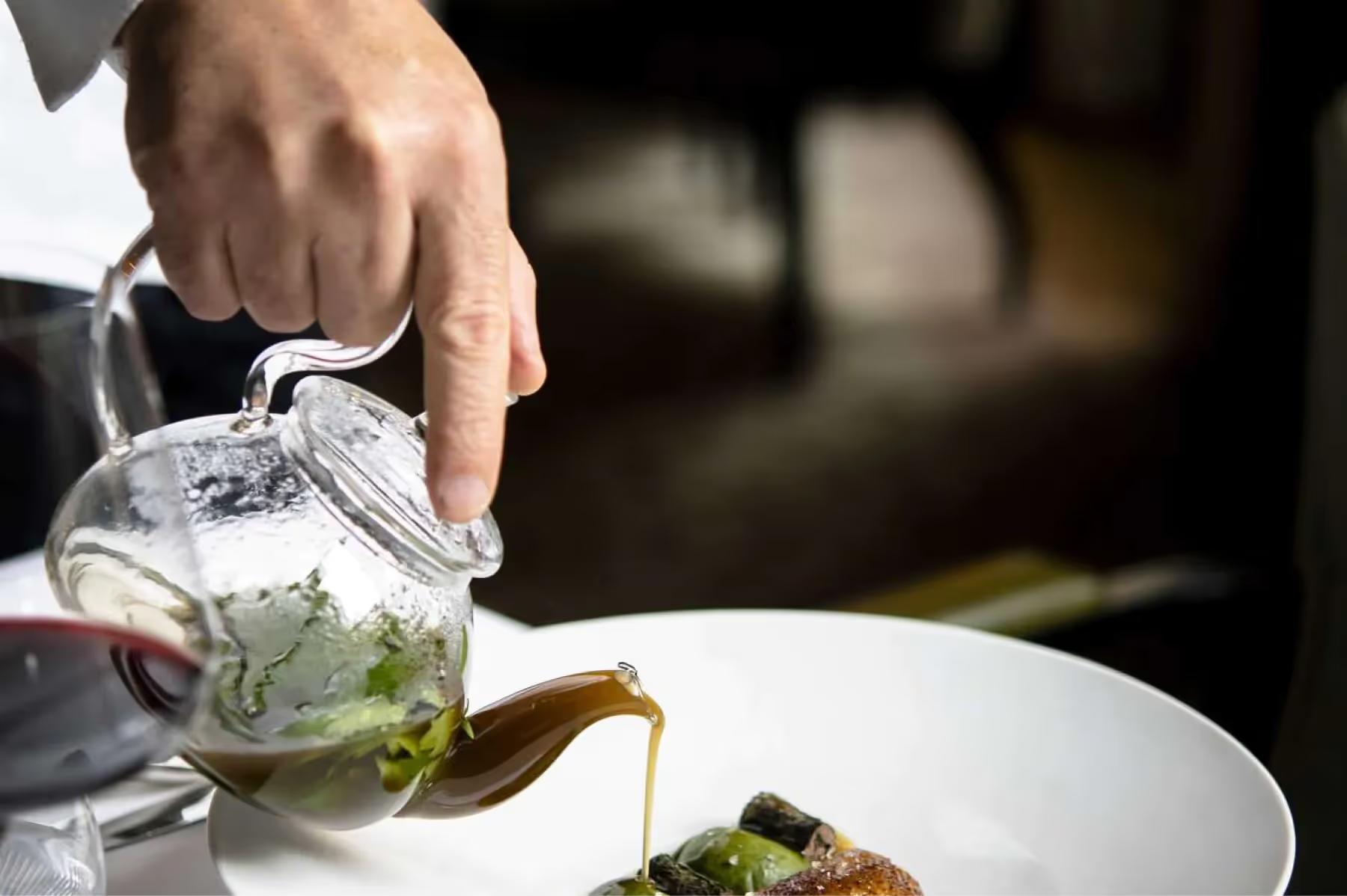 La Réserve Paris: a server pouring dressing over a salad plate with precision