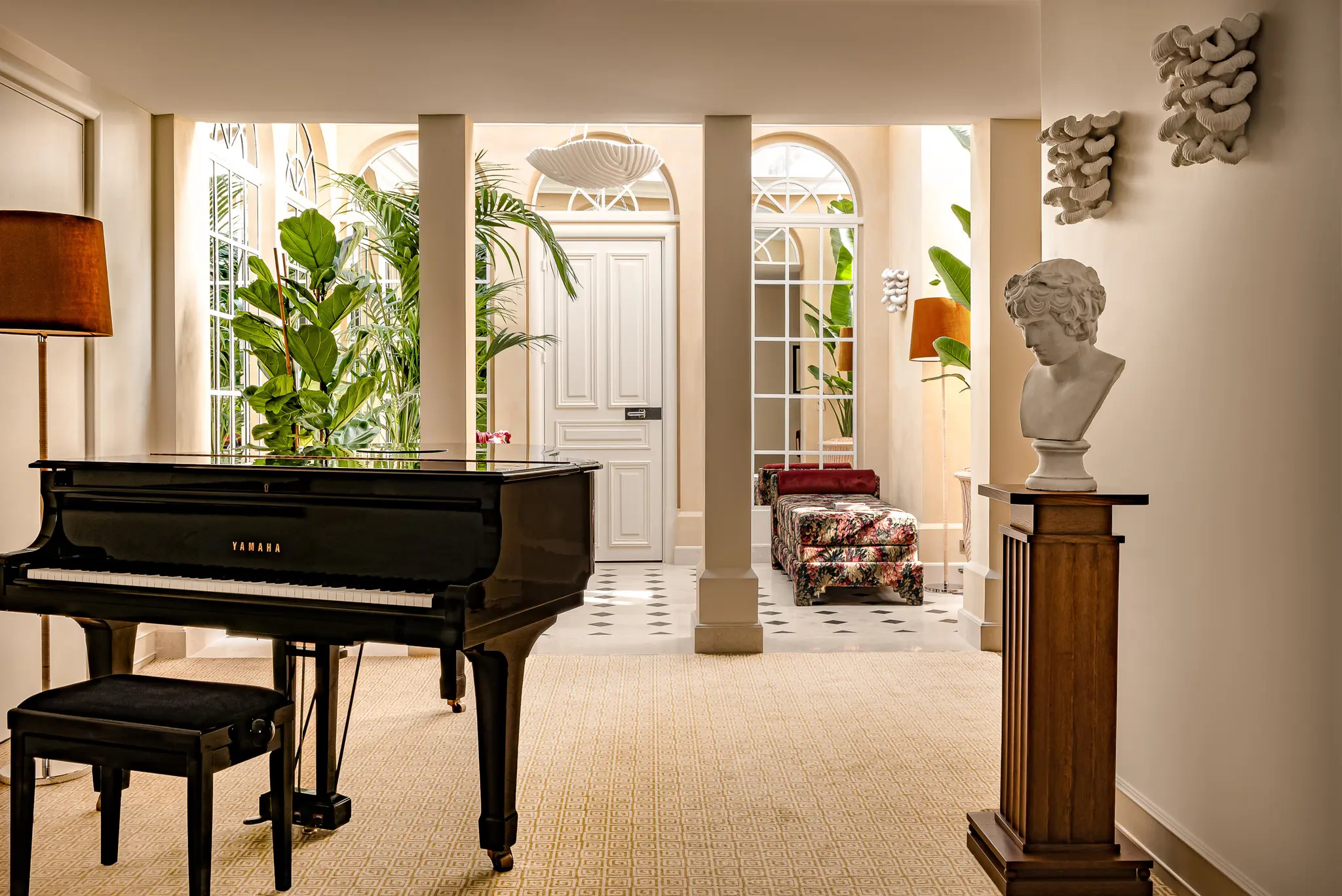 Saint James: grand music room with black grand piano, classical columns, and tall French doors