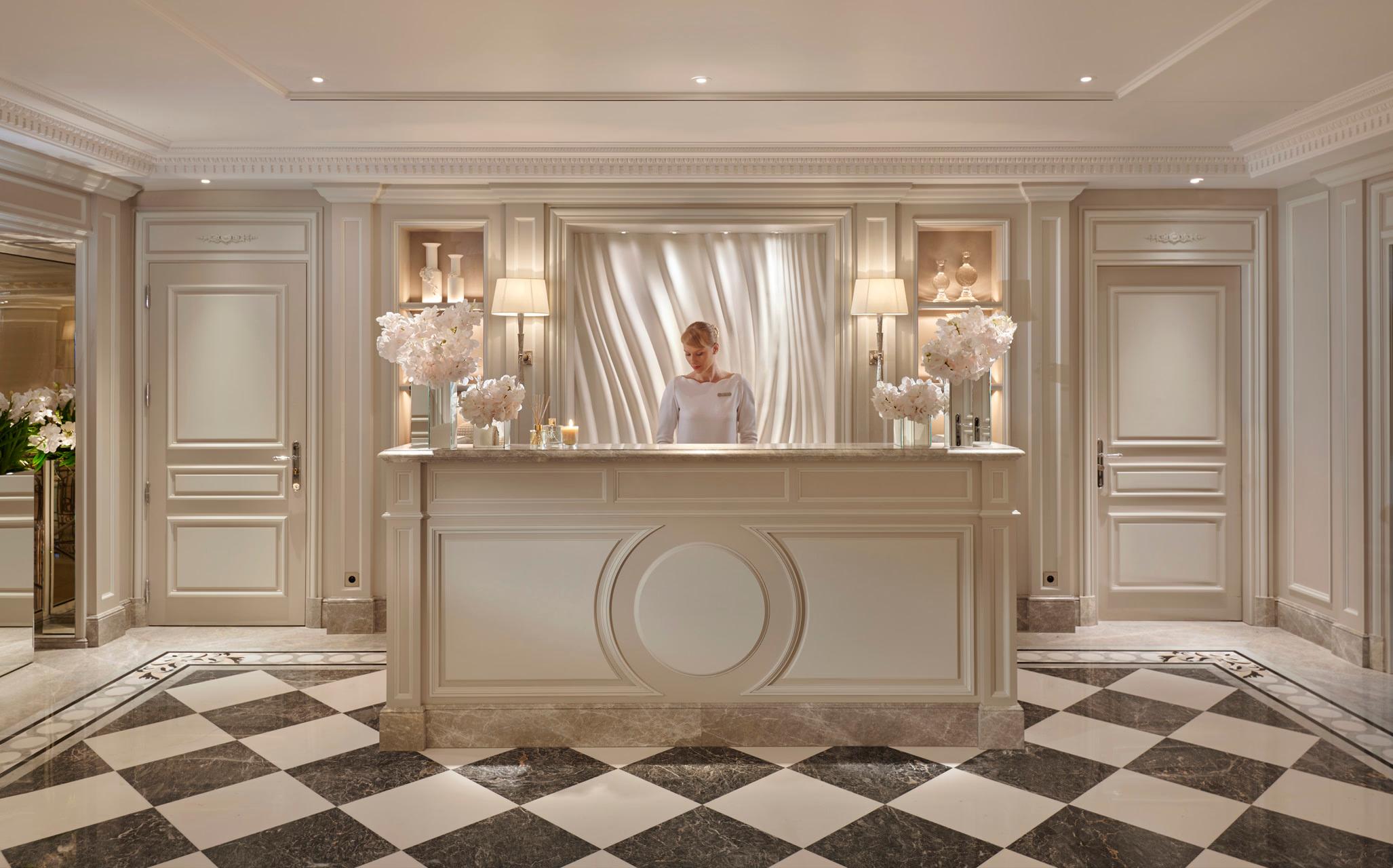 Four Seasons Hotel George V: a spa reception area with cream walls, crown molding, and glass shelving