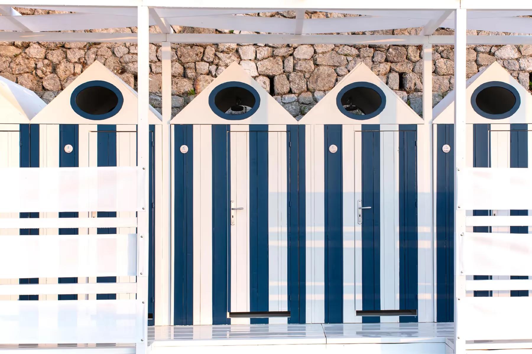 Borgo Santandrea: striped beach cabanas with dark blue and white panels lining the waterfront