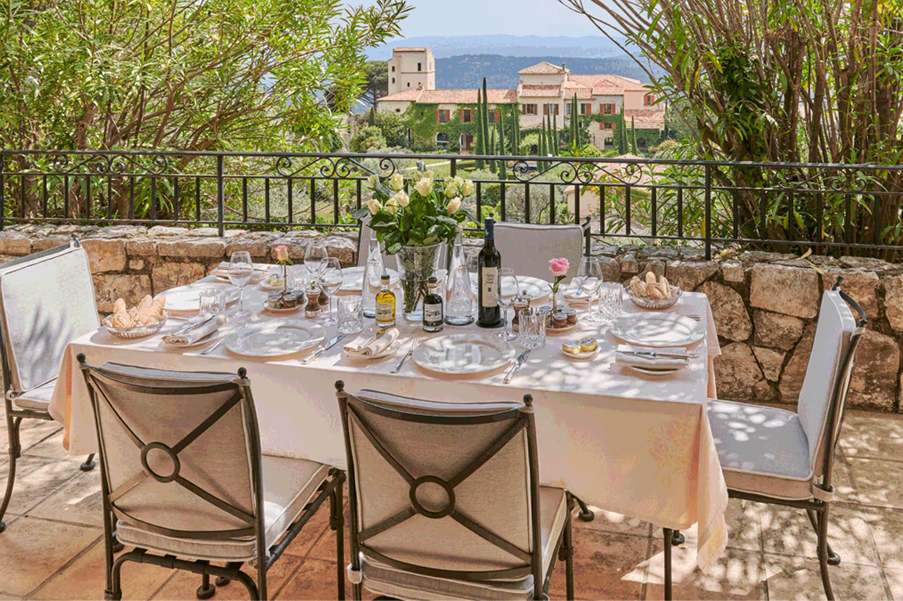 Château Saint Martin & Spa: outdoor dining setup on stone terrace overlooking forested hillside