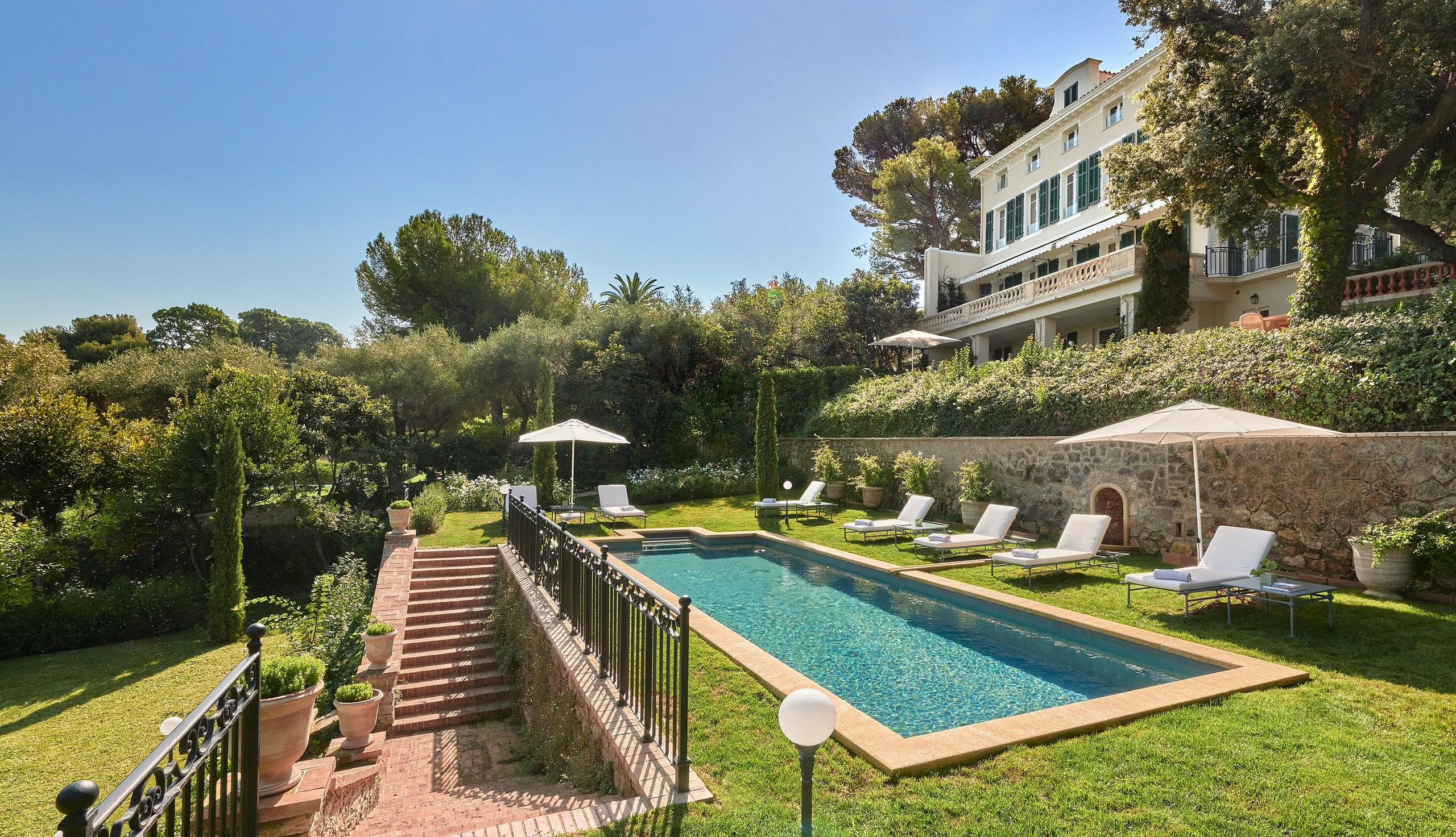 Hôtel du Cap-Eden-Roc: a private terraced garden with lounge seating, umbrellas, and views over the Mediterranean