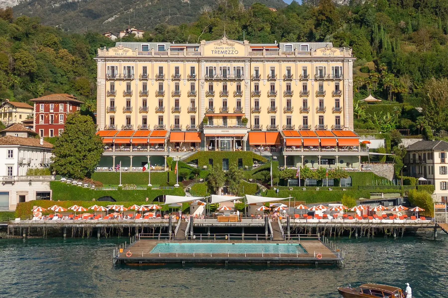 The palatial facade of the Art Nouveau hotel with orange awnings facing Lake Como