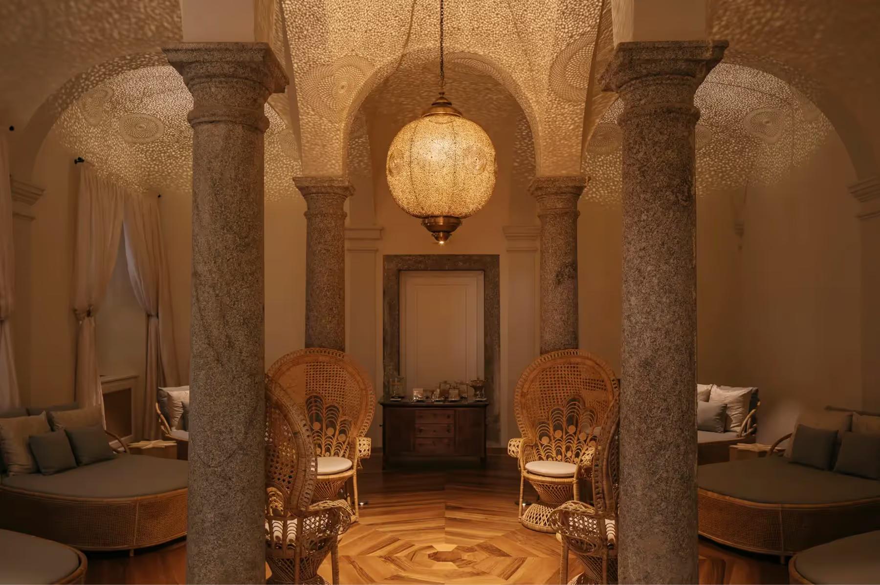 Passalacqua: a spa corridor with stone columns, accent lighting, and arched ceiling