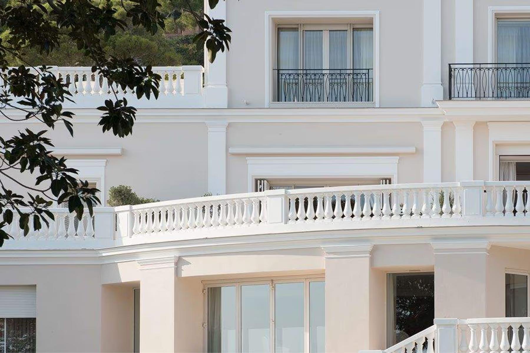 Hotel Cap-Estel: a white neoclassical facade with arched windows and stone balconies
