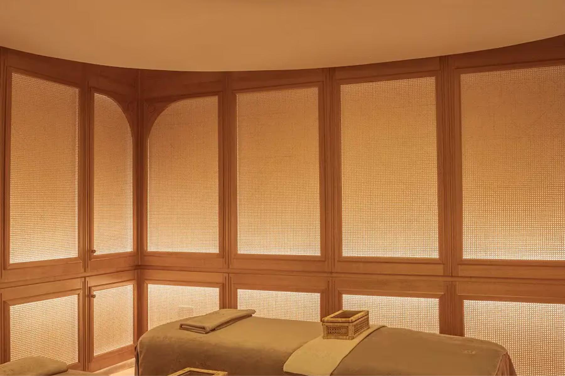 A curved sauna interior with wooden bench seating and light wood walls
