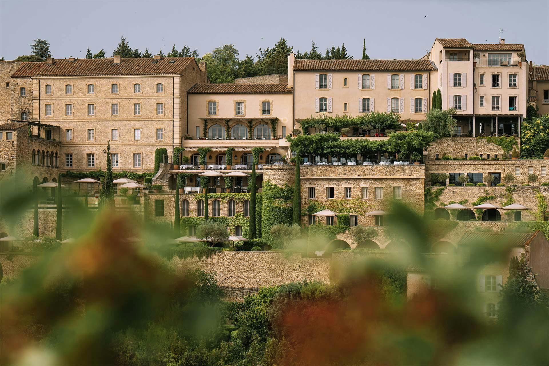 Airelles Gordes, La Bastide: the honey stone facade of the hotel rising from terraced gardens
