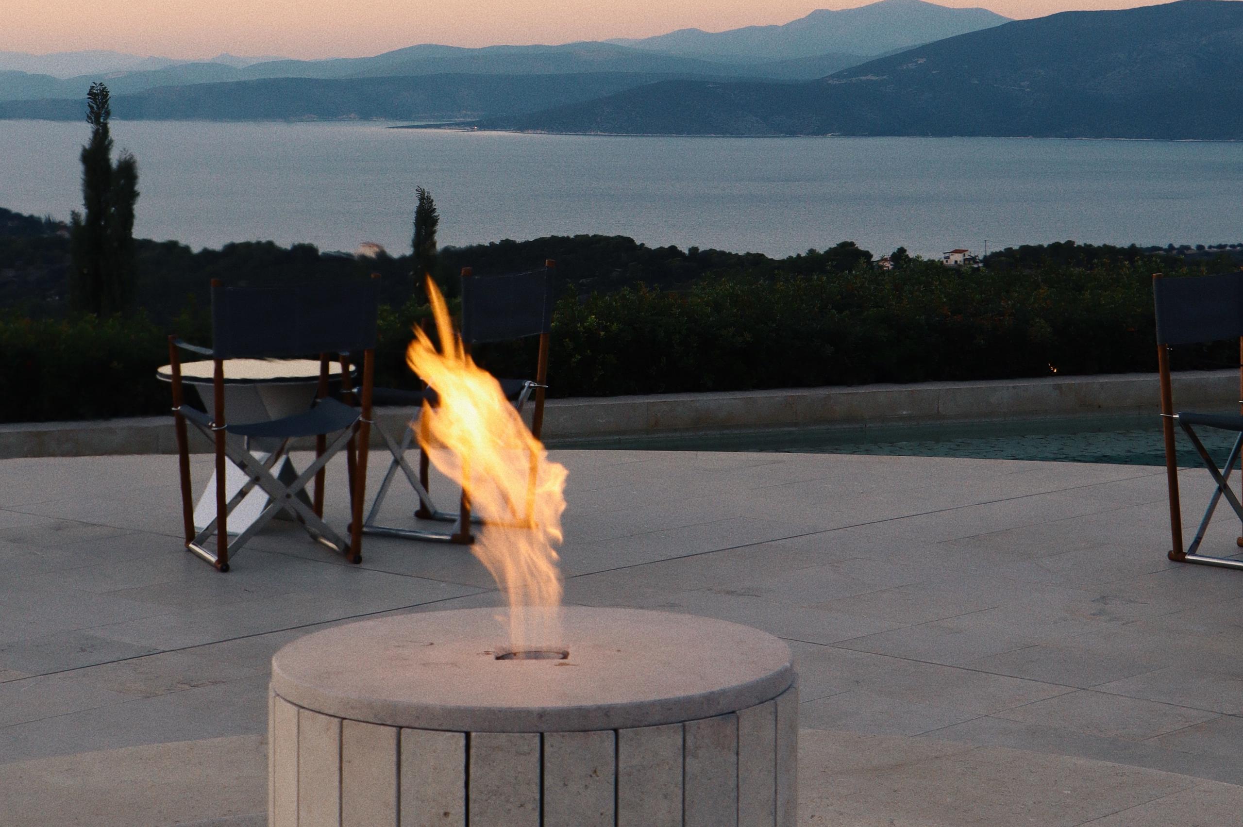 Intimate waterside dinner with fire feature at twilight
