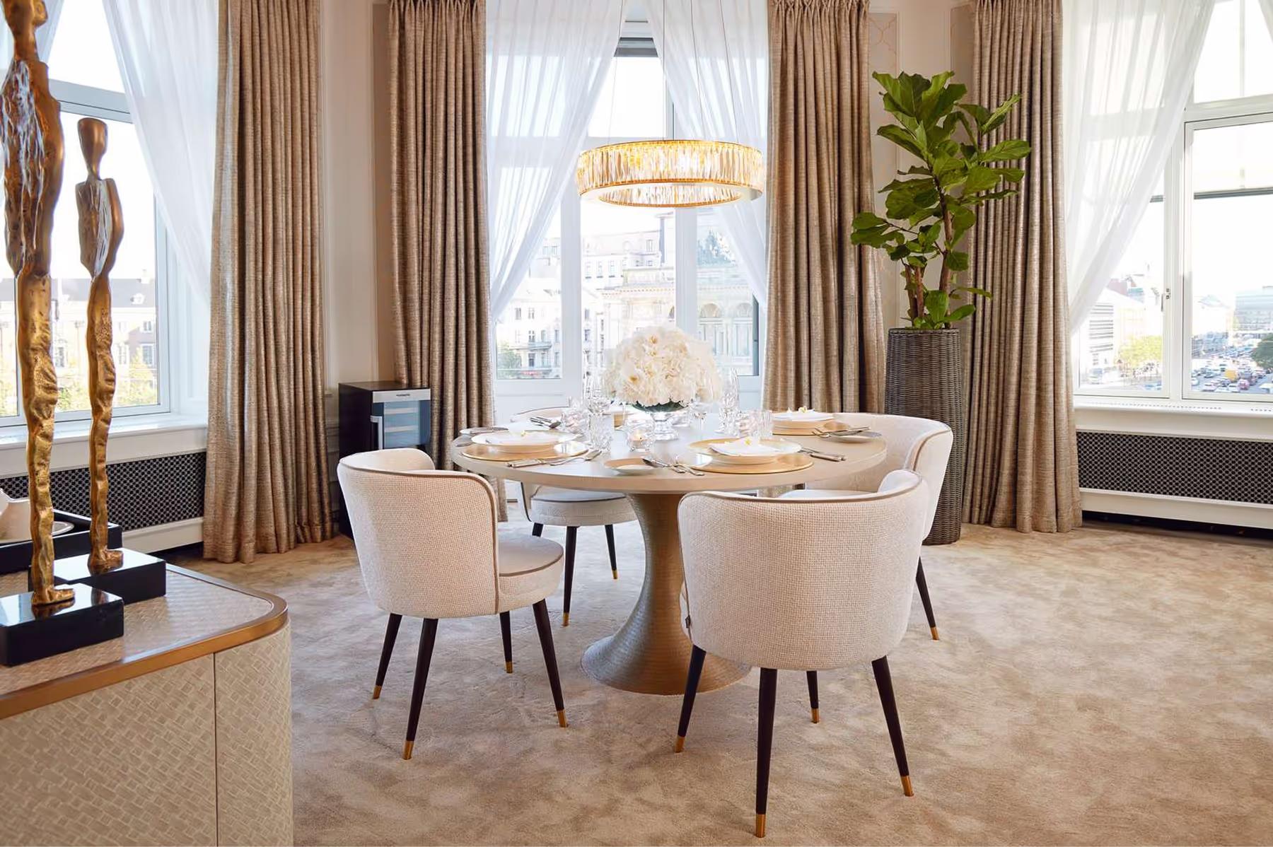 Parlor room with round dining table, natural light, and curtained windows