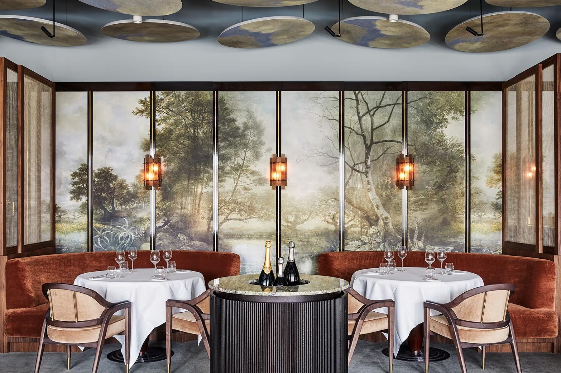 Dining room with glass wine display, terracotta walls, and brass fixtures