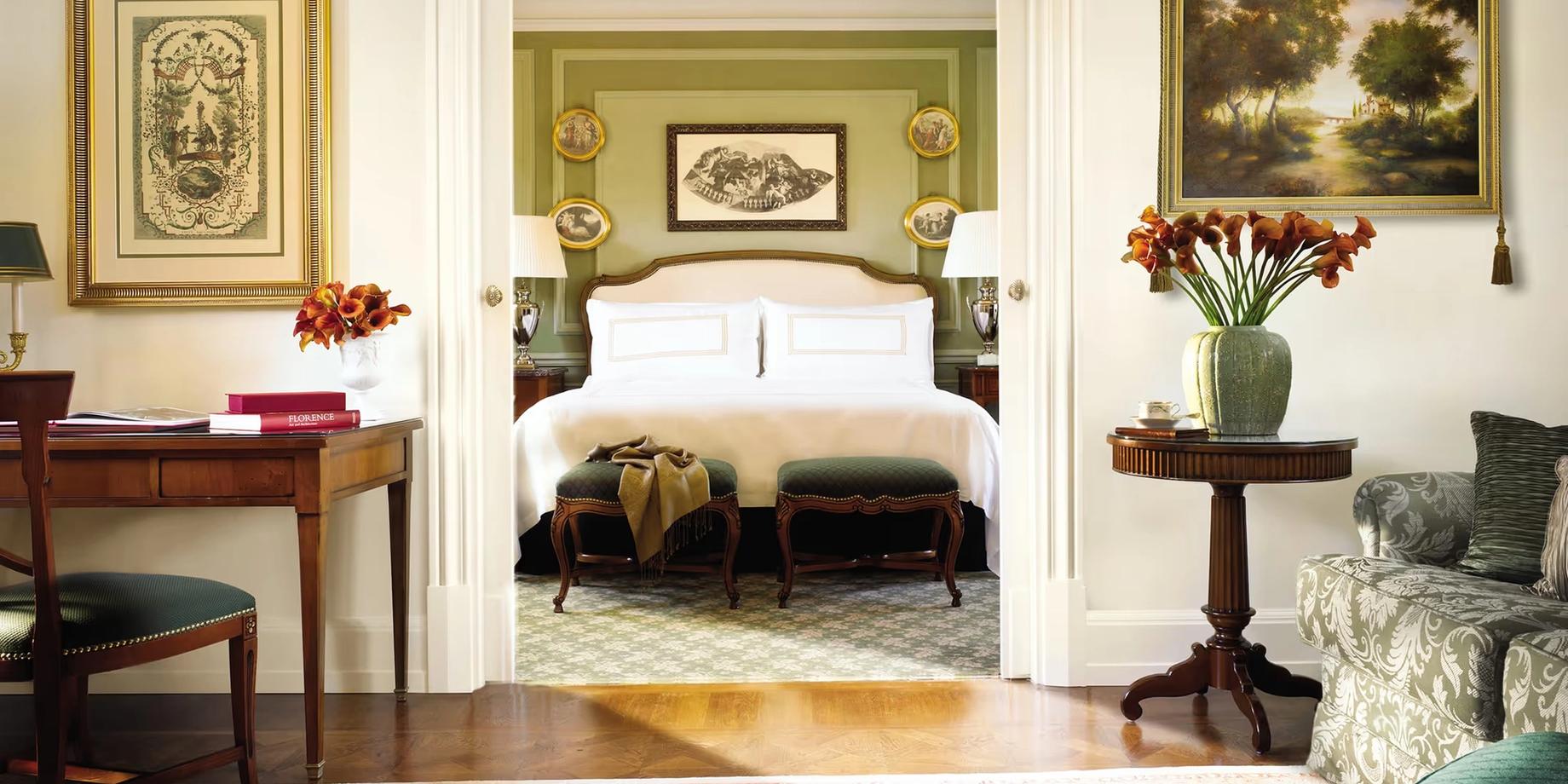 A guest suite with cream-colored walls, an ornate fireplace, and framed artworks