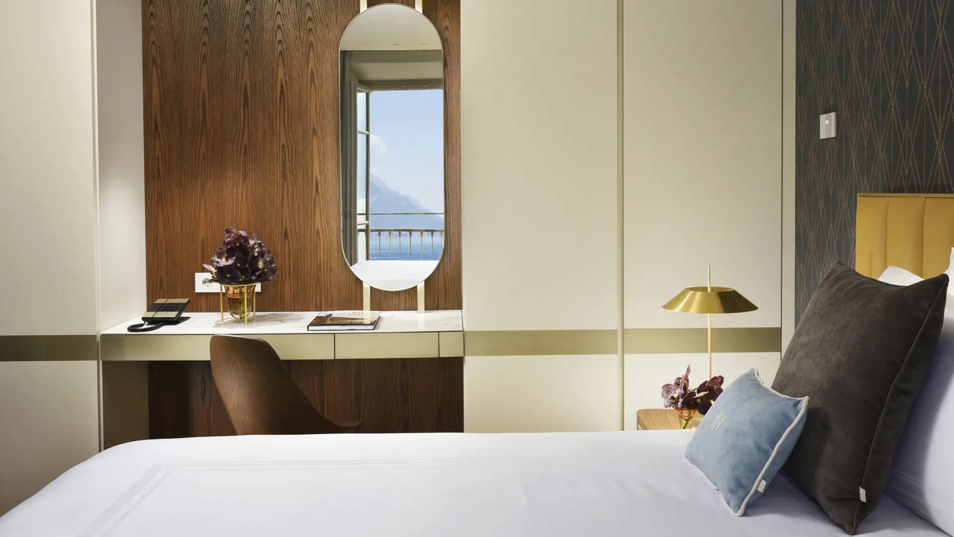 Grand Hotel Victoria Concept & Spa: a bedroom with pale walls, natural light from doors, and wood furnishings
