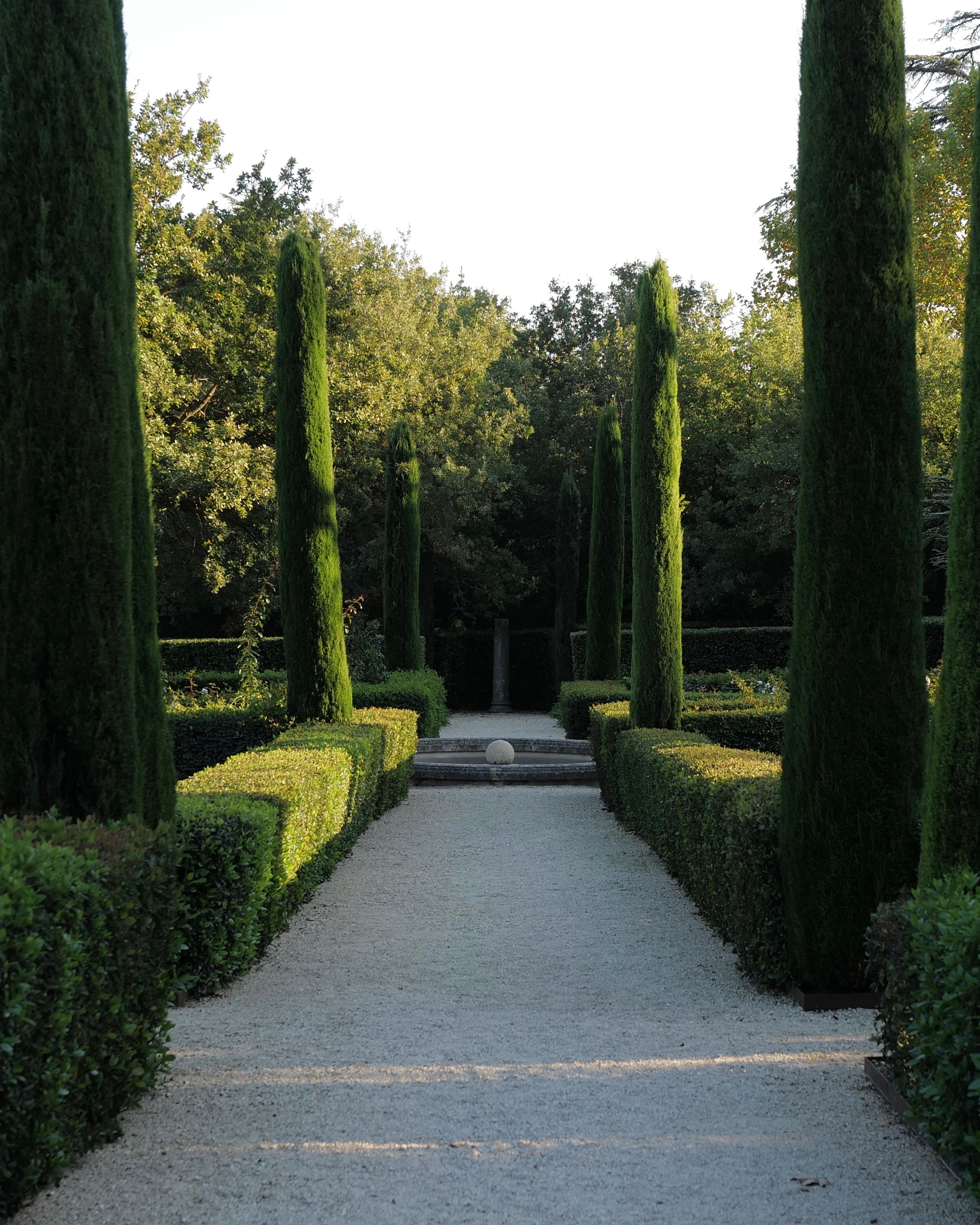 A formal Provence garden framed by cypress trees