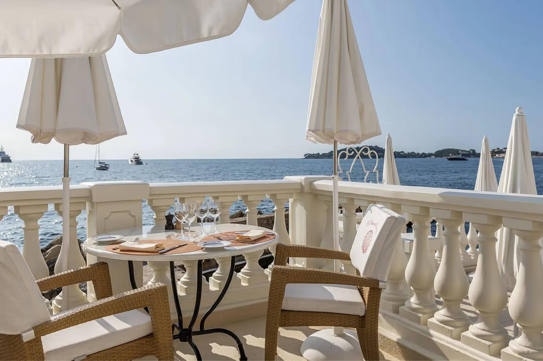 La Réserve de Beaulieu: outdoor terrace dining with white umbrellas and sea views
