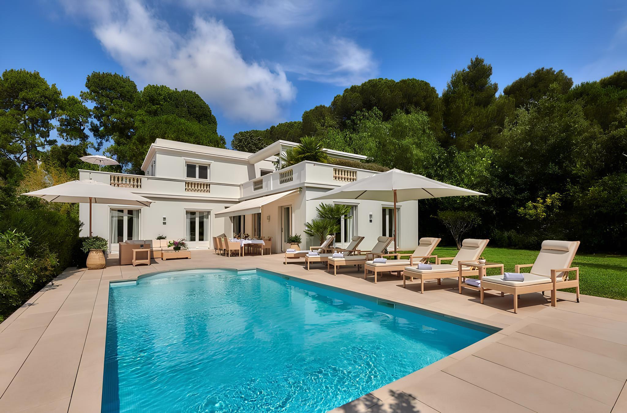 Hôtel du Cap-Eden-Roc: an aerial view of a pink Mediterranean villa with a turquoise pool and surrounding manicured grounds