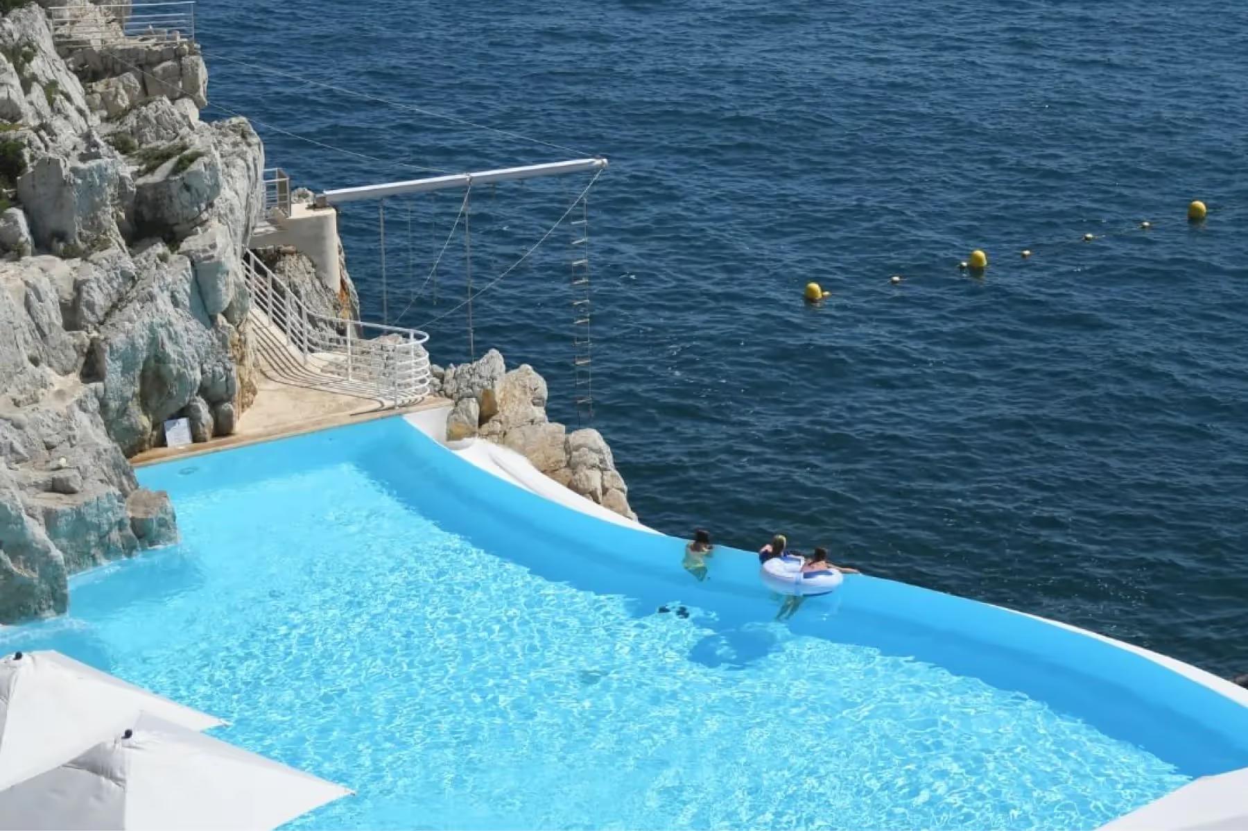 Hôtel du Cap-Eden-Roc: a rocky cliff-carved pool edge overlooking deep blue Mediterranean waters