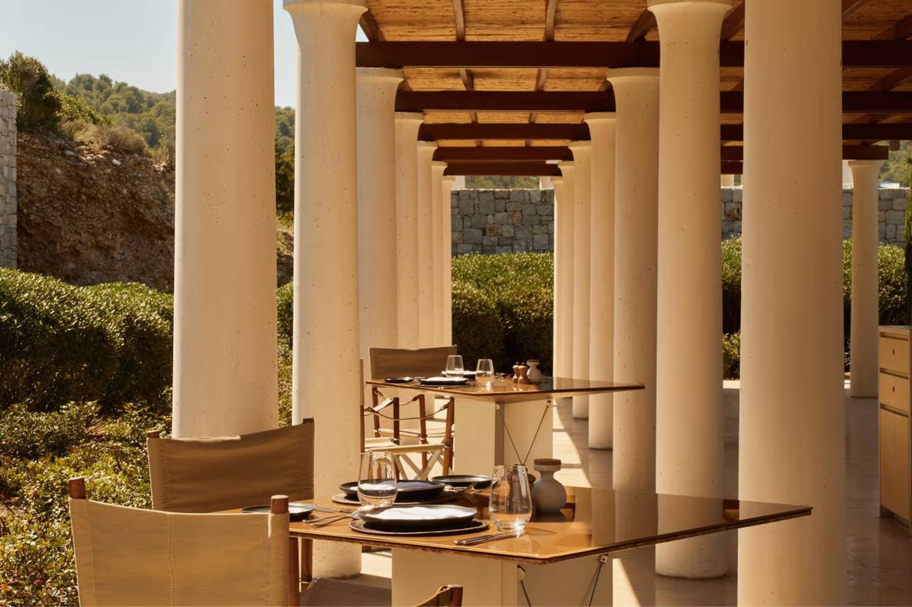 Amanzoe: columned restaurant interior with laid table overlooking countryside