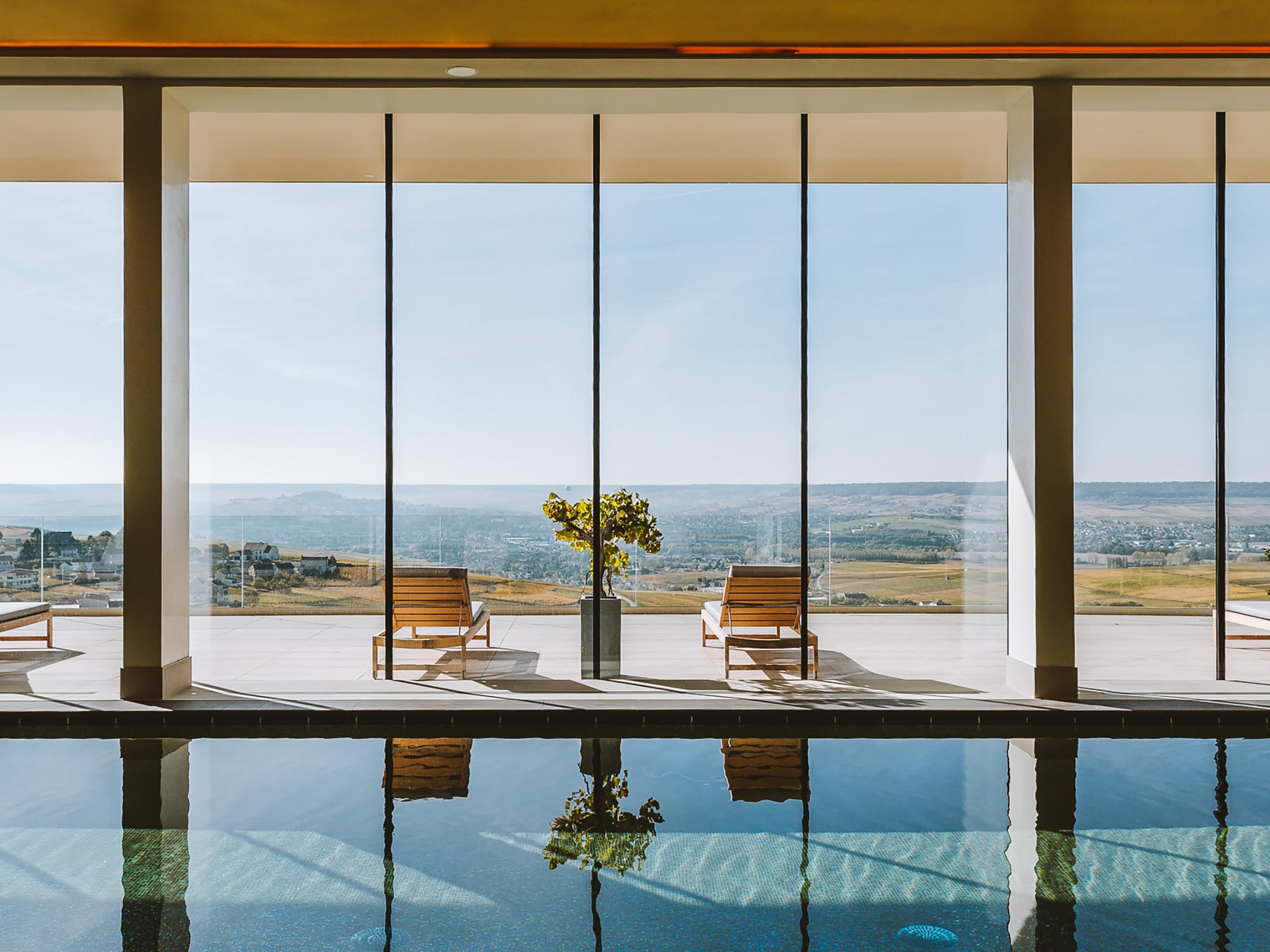 Royal Champagne Hotel & Spa: indoor pool with floor-to-ceiling windows framing vineyard landscape