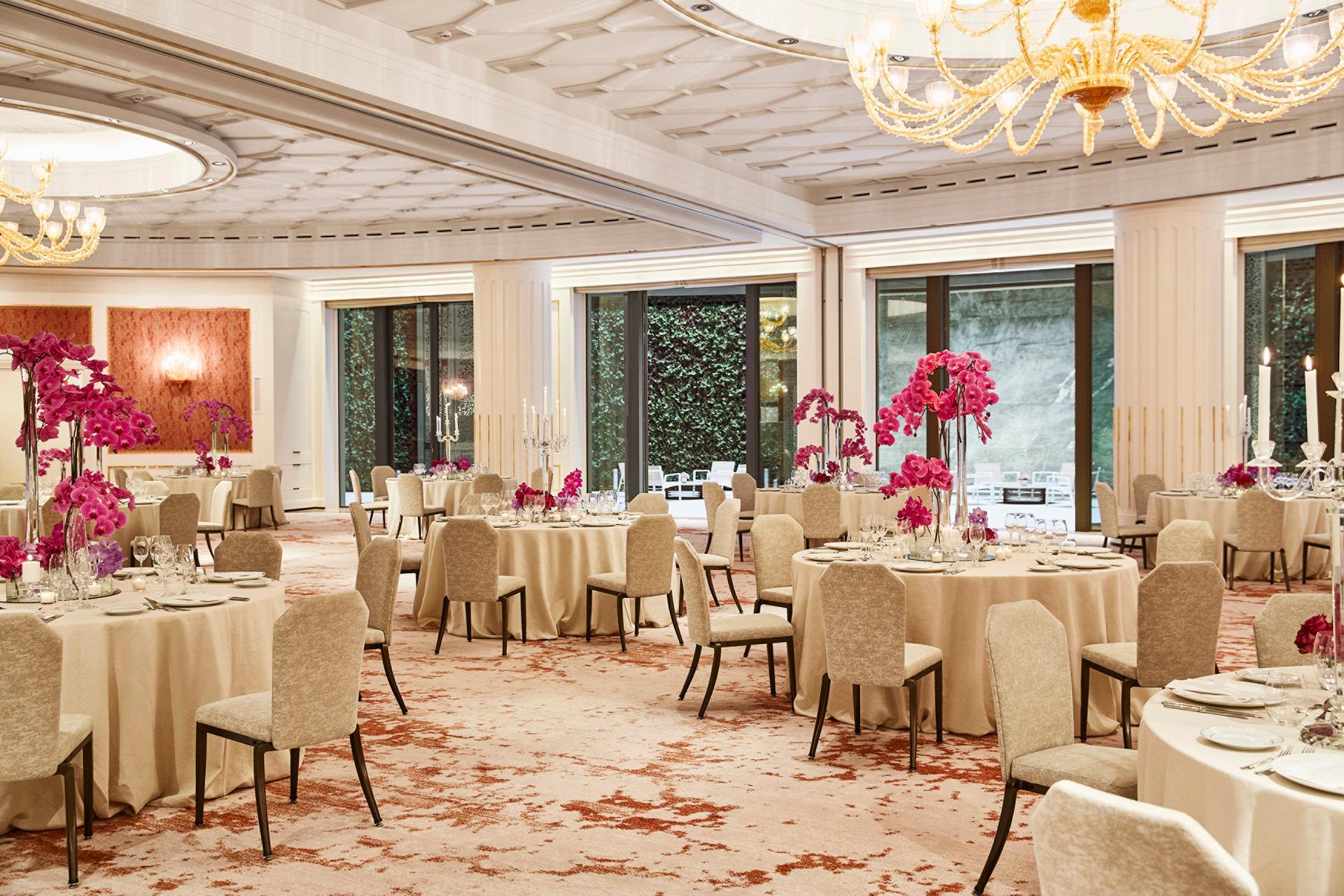 Four Seasons Hotel Madrid: banquet hall with cream upholstered chairs, crystal chandeliers, and floral centerpieces