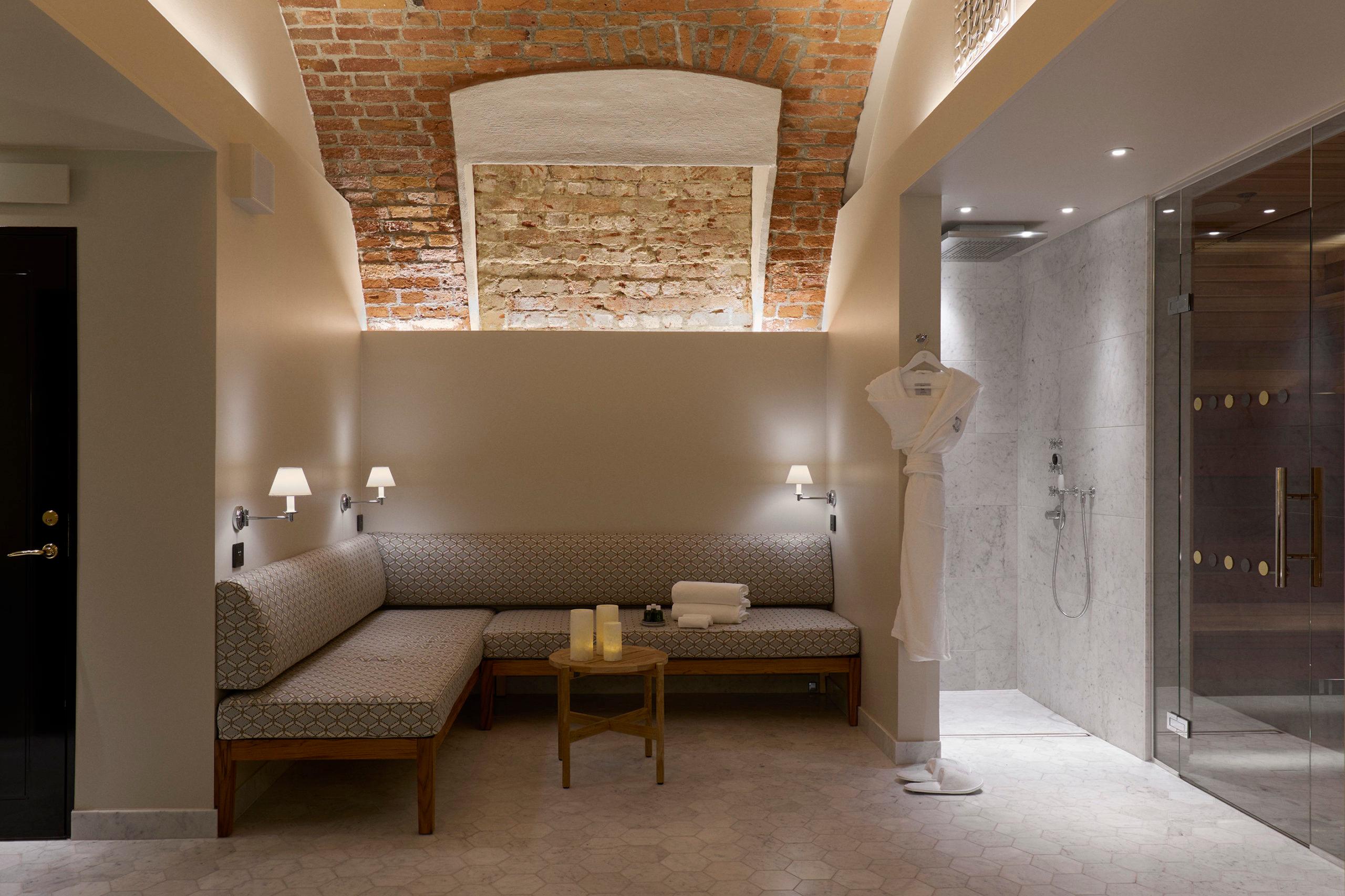 Spa relaxation lounge with exposed brick ceiling, bench seating, and ambient lighting