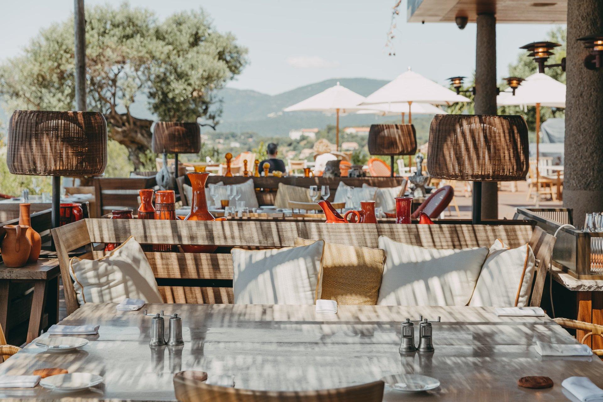 Lily of the Valley: outdoor dining area with striped chairs and mountain views beyond