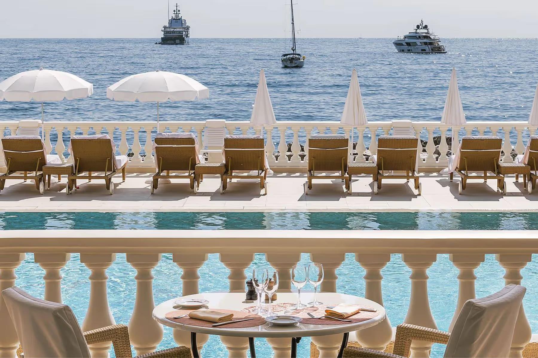 La Réserve de Beaulieu: upper terrace with sea views, umbrella canopies, and dining table