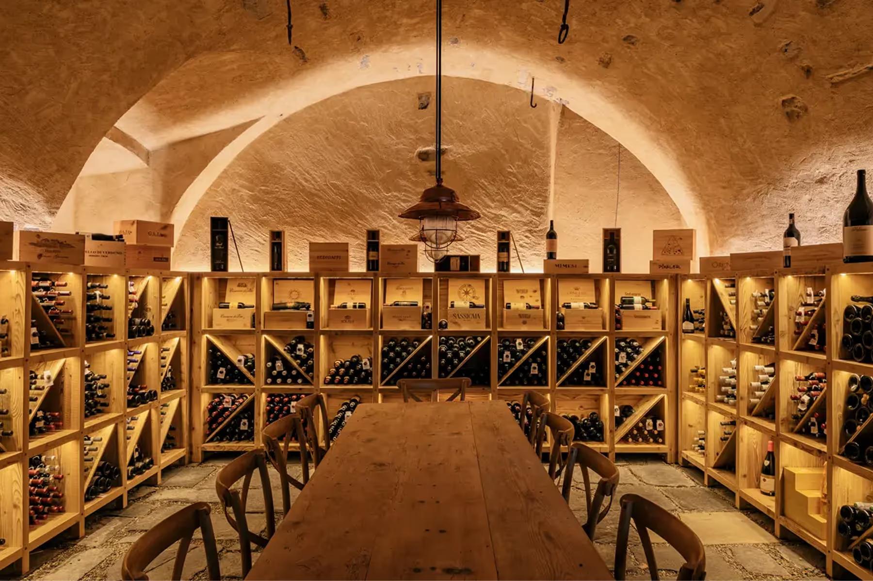 Grand Hotel Tremezzo: underground wine cellar with wooden chairs lining curved stone walls