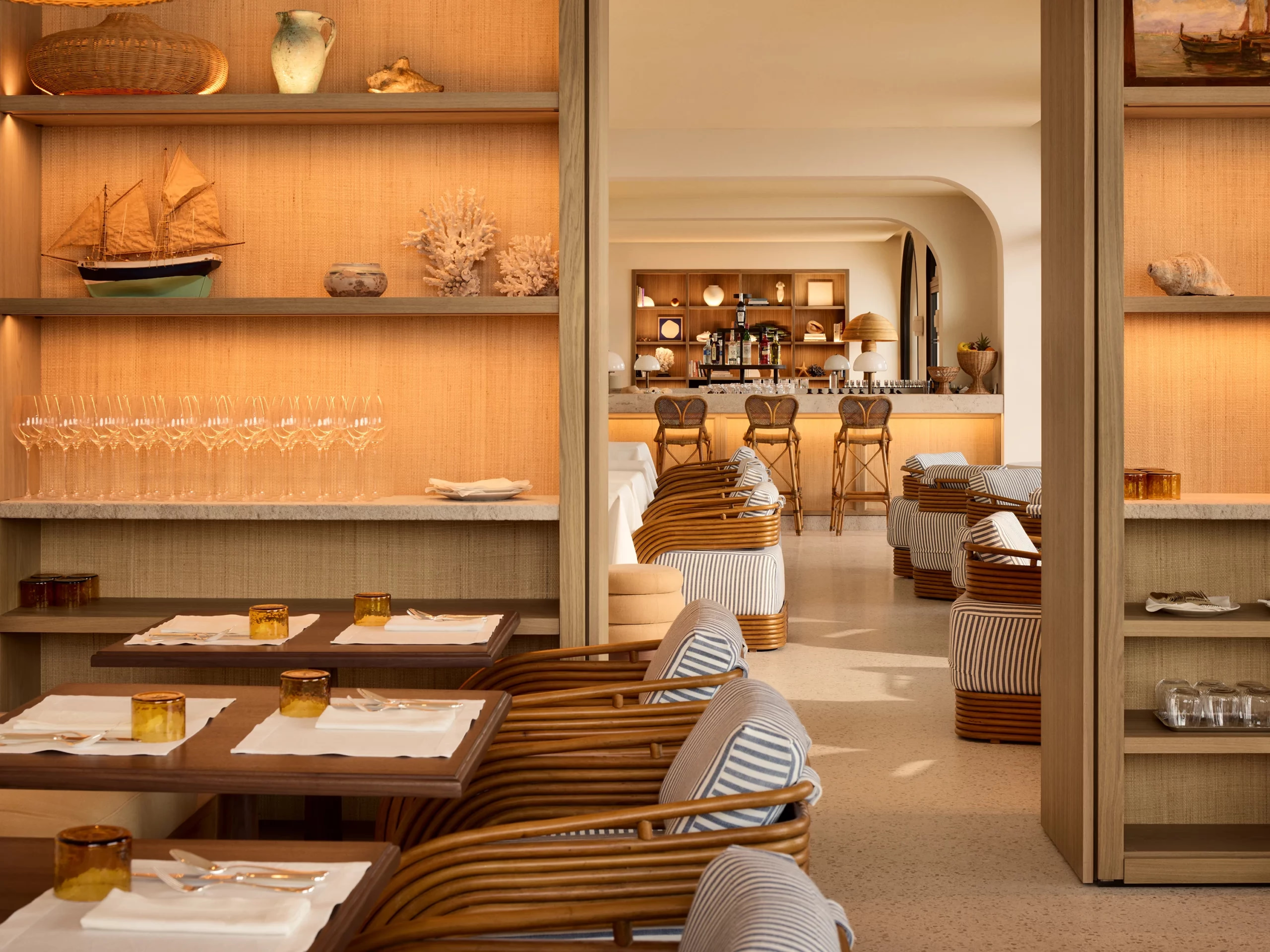 Zannier Île de Bendor: model ships and coral sit on oak shelving between the dining room and bar beyond
