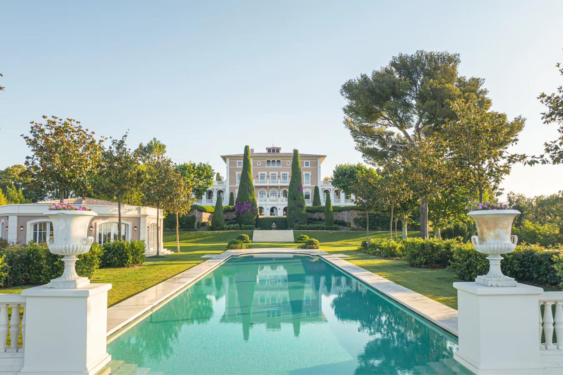 Le Château de La Croix des Gardes: rectangular lap pool with stone decking, cypress trees, and sea horizon beyond