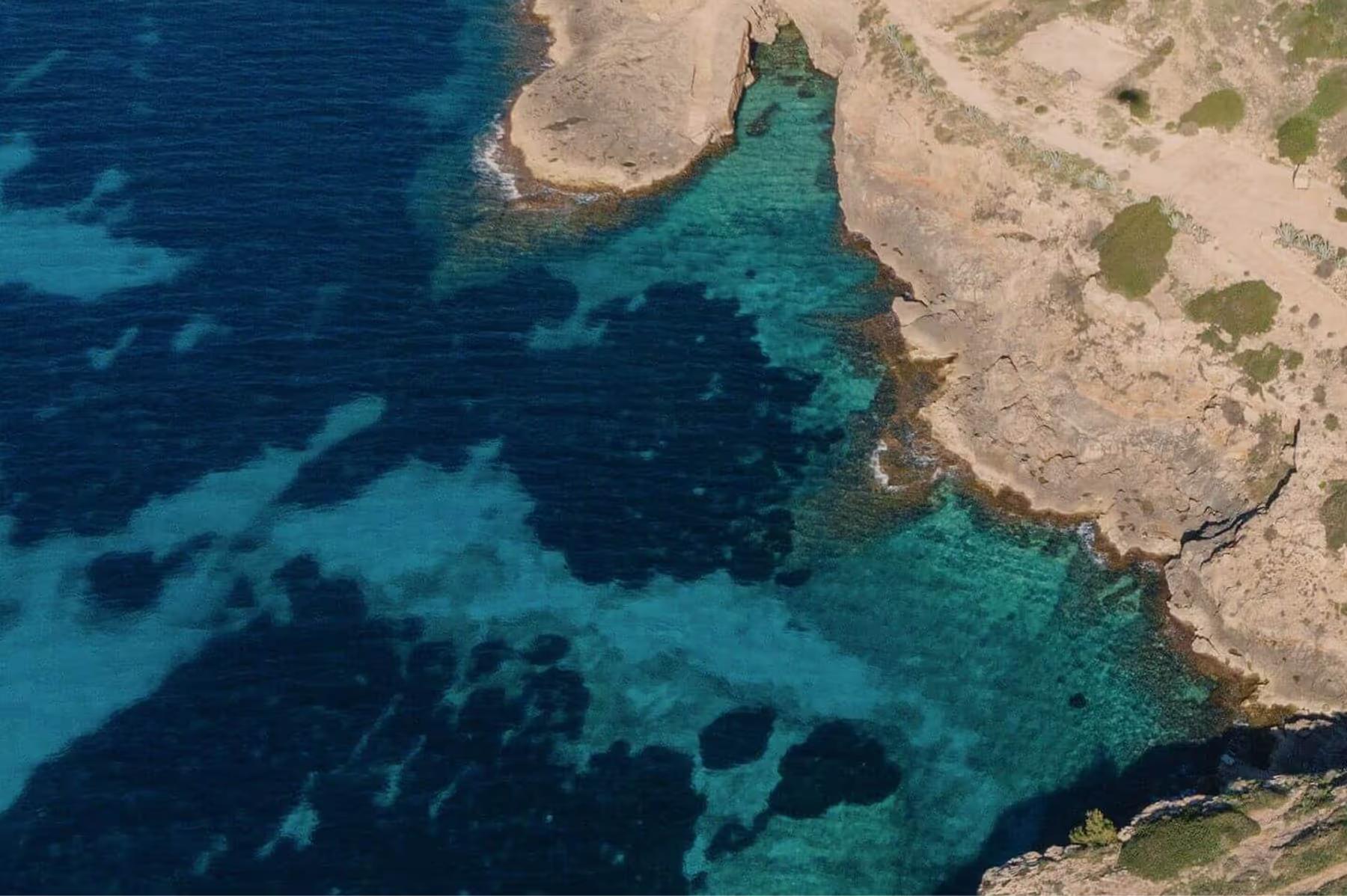 Pale sandy coves and deep turquoise water with rocky outcrops along the Mallorca coast