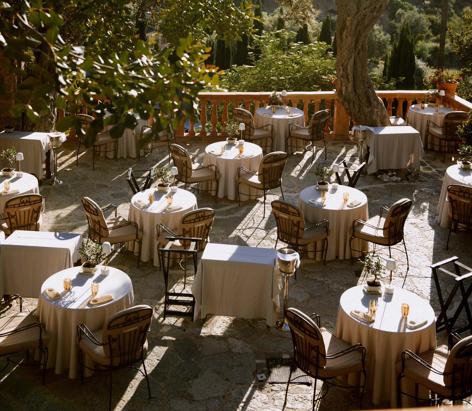 Candlelit terrace tables beneath old trees in Mallorca