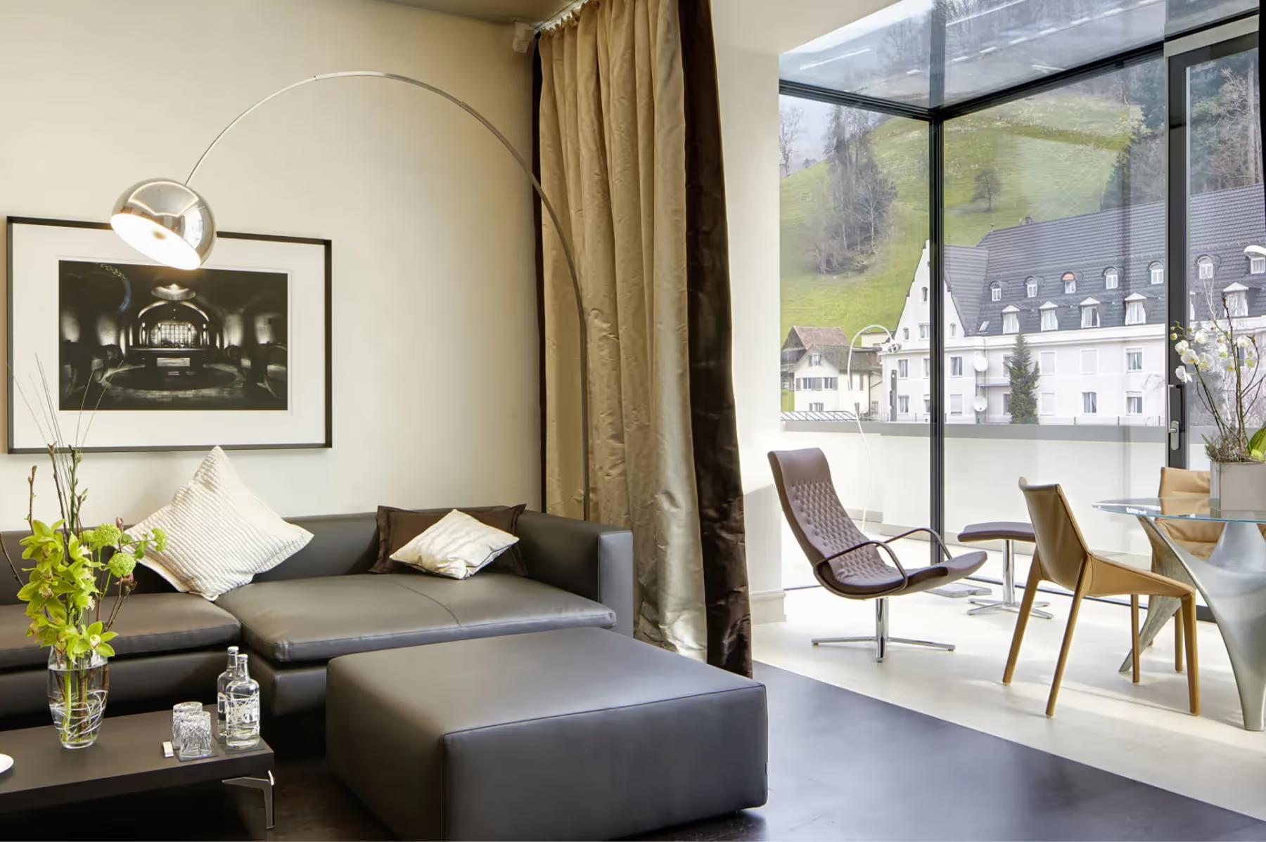 Park Hotel Vitznau: sitting area with dark seating, large windows framing mountain and lake views