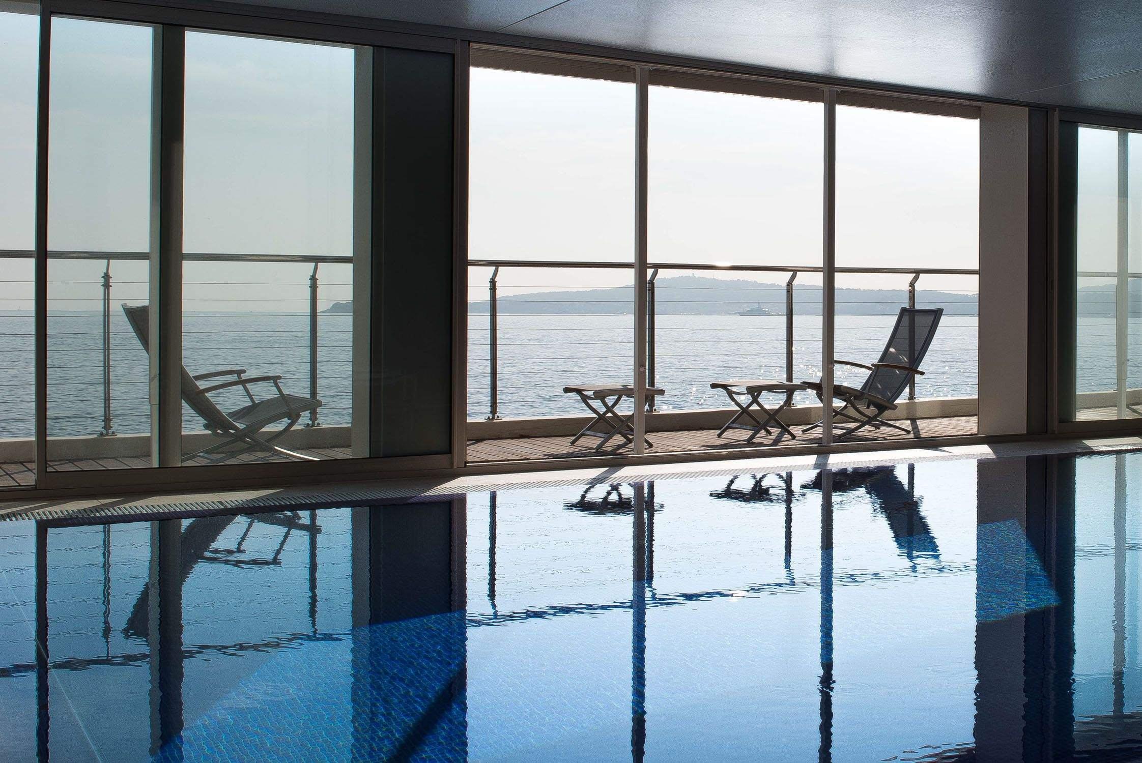 Hotel Cap-Estel: an indoor pool with floor-to-ceiling windows and sea views
