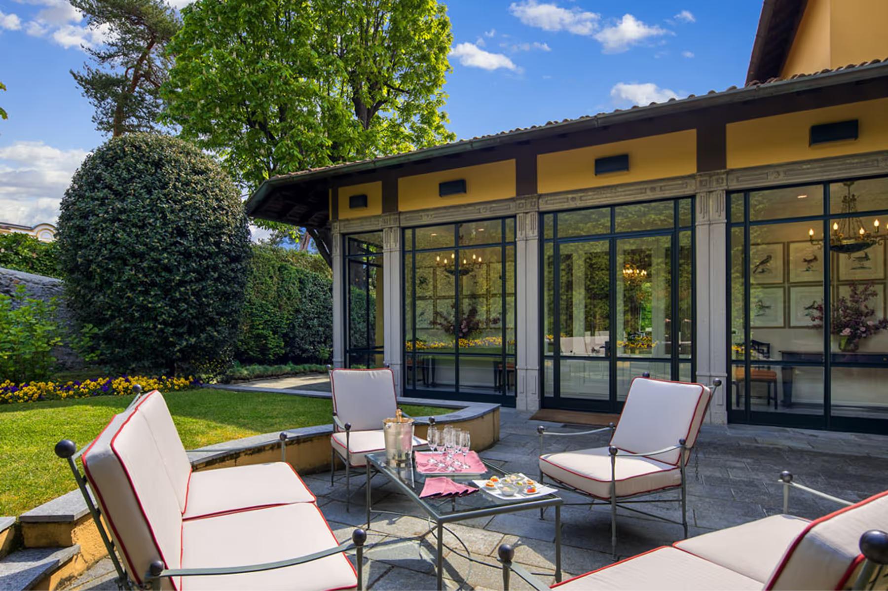 Outdoor terrace with lounge seating and lake views beneath a pergola structure