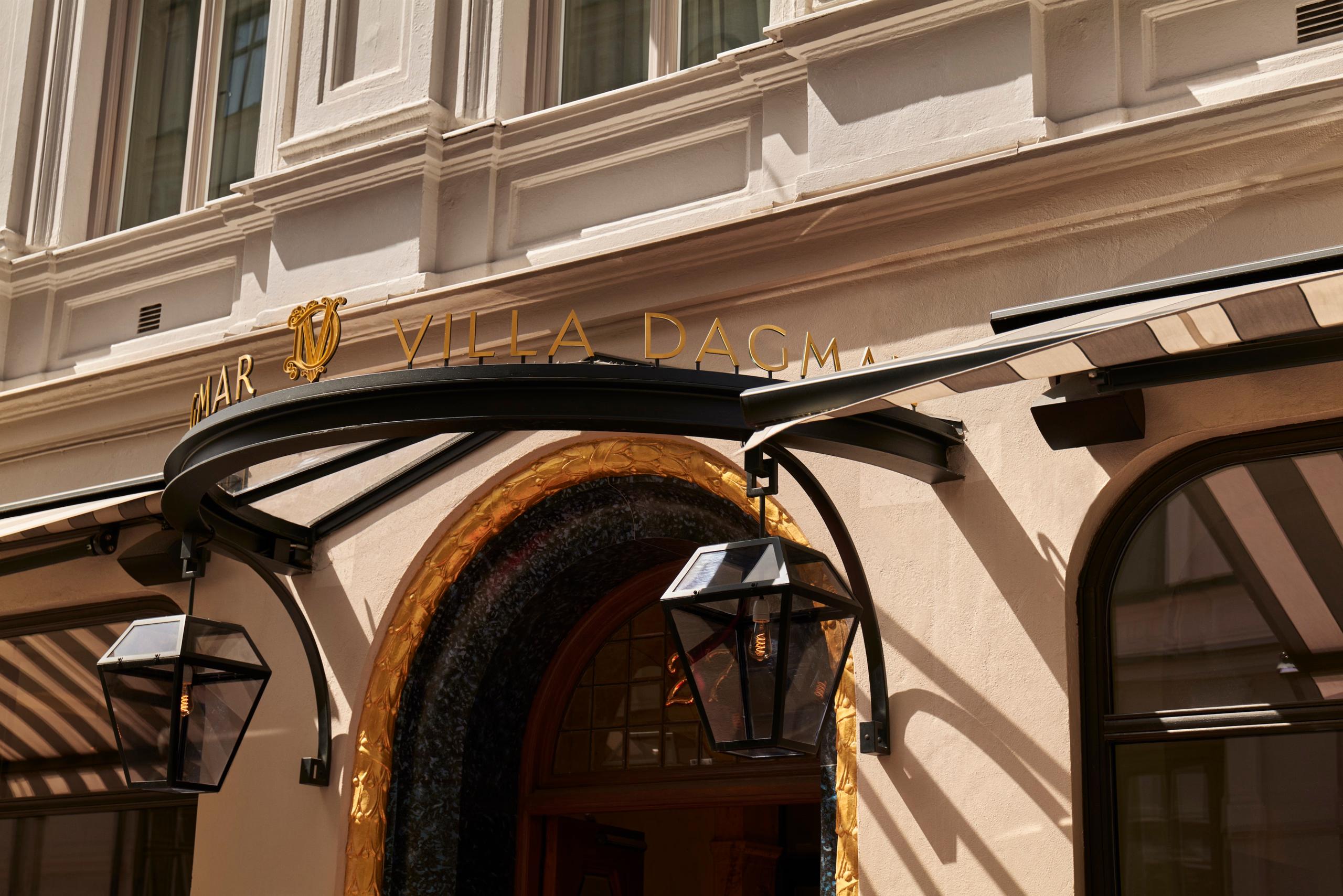 Villa Dagmar: cream-colored facade with ornate architectural details and street-level storefronts