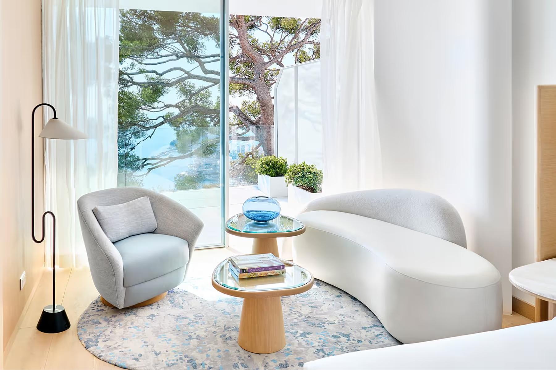 Bedroom with light wood accents and window seating overlooking water