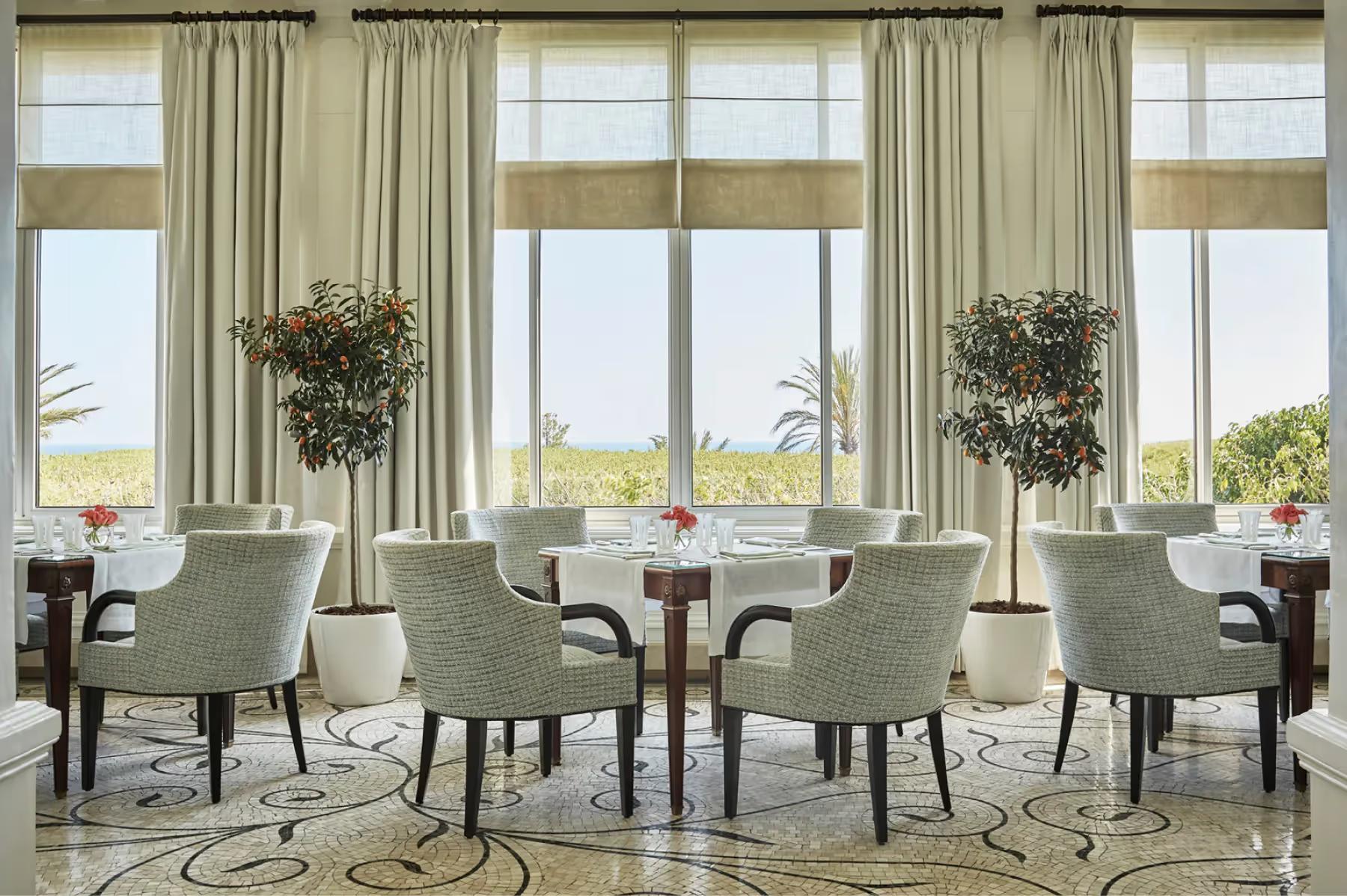 Bright dining area with floor-to-ceiling windows and contemporary furnishings