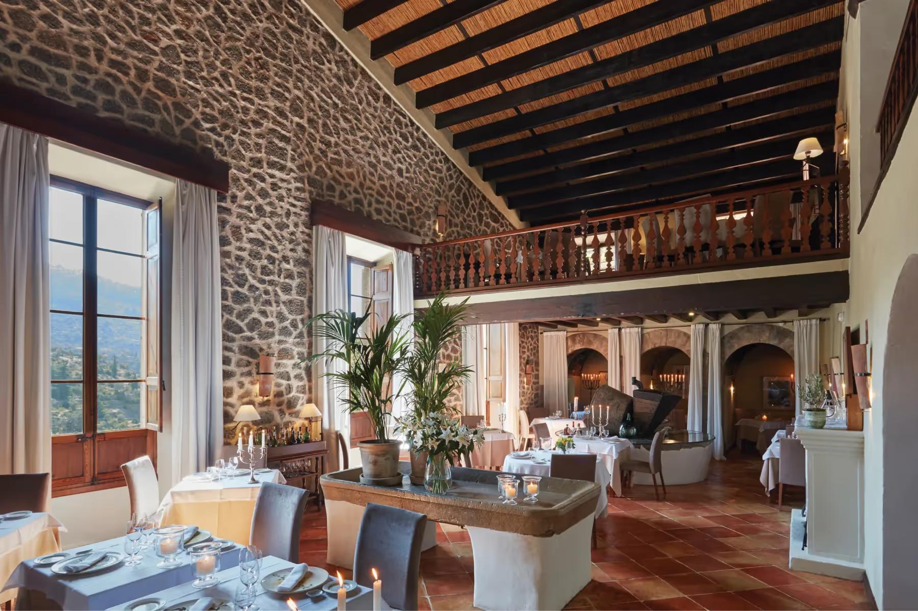 La Residencia: interior restaurant with stone walls, wooden beam ceiling, gallery level, and Mediterranean ambiance