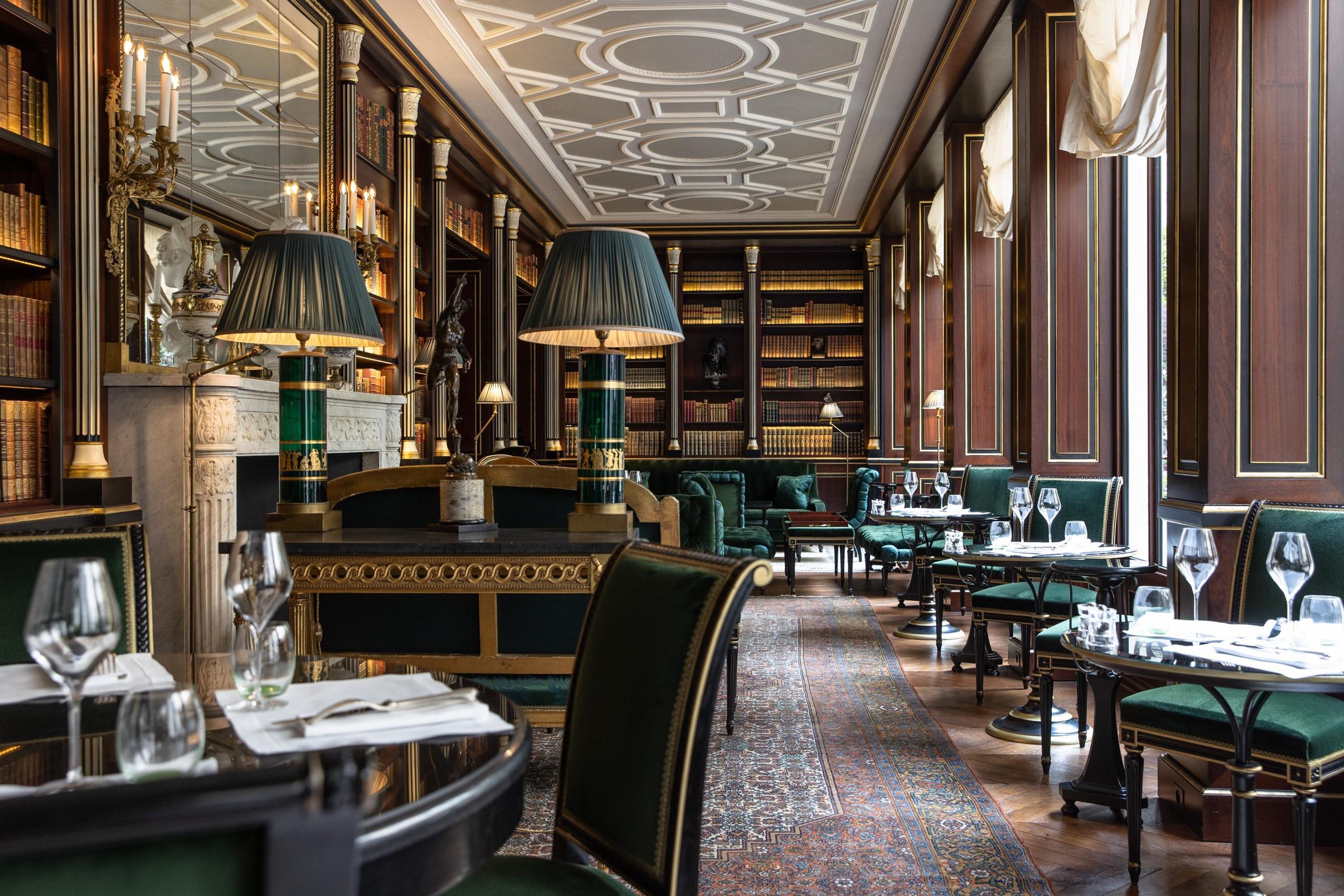 La Réserve Paris: the dining room with black leather banquettes, gilded paneling, and jewel-toned furnishings