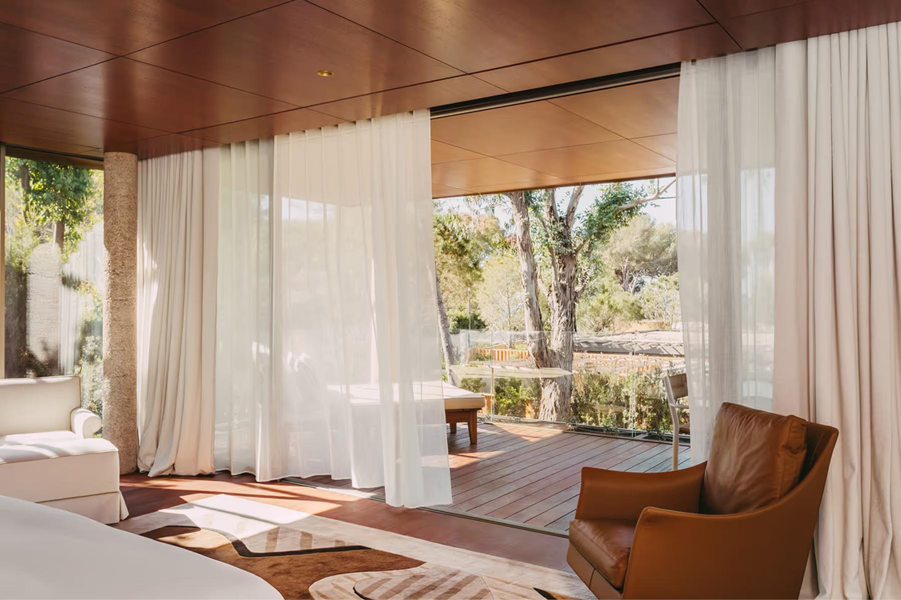 Spa treatment room with sheer curtains and bright natural light from large windows