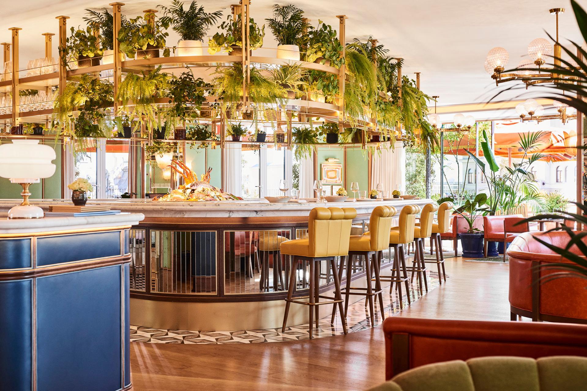 Four Seasons Hotel Madrid: bar and lounge with green and gold decor, living plant wall, wood paneling, and cocktail seating