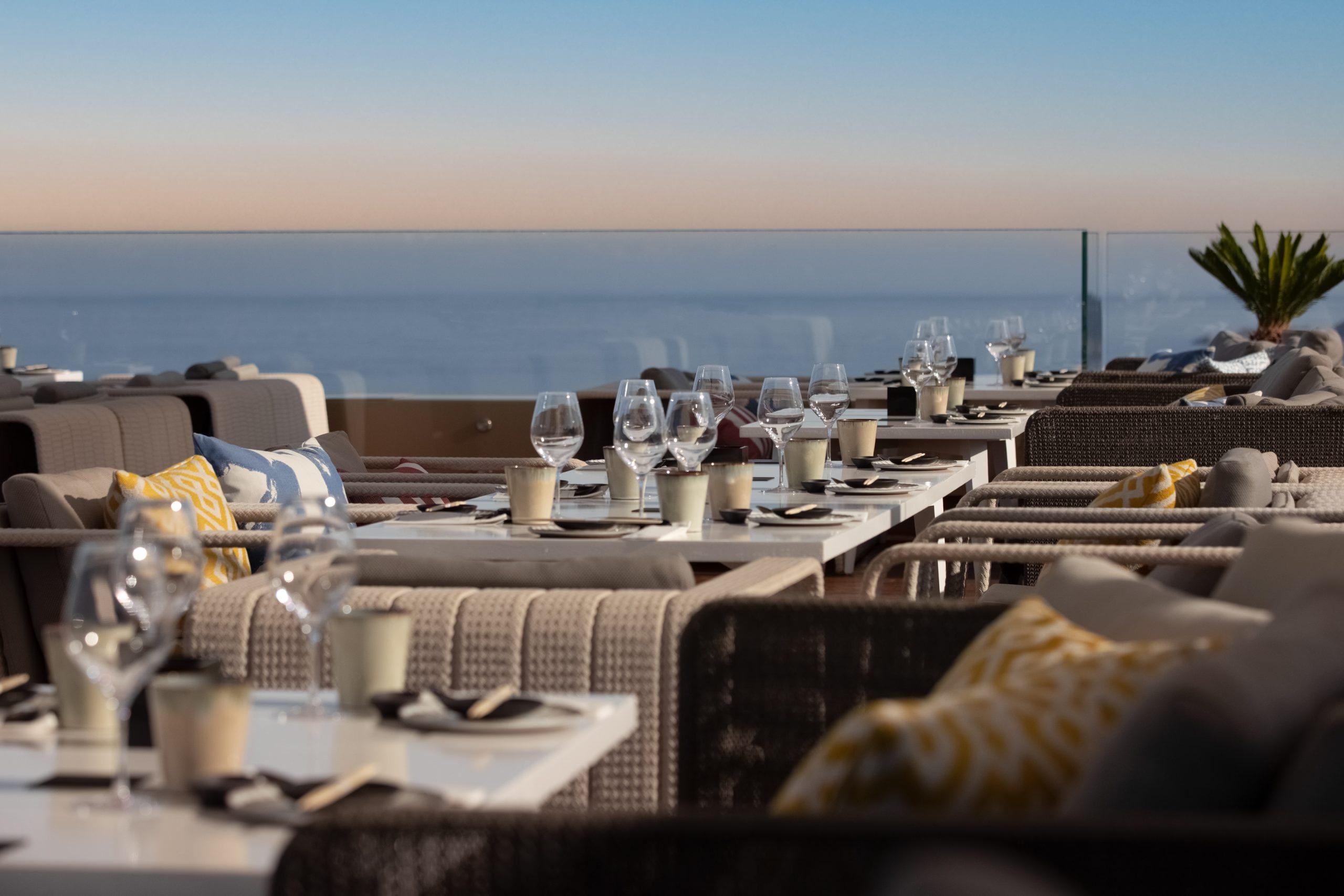 La Réserve Ramatuelle: oceanside dining terrace at sunset with white table settings