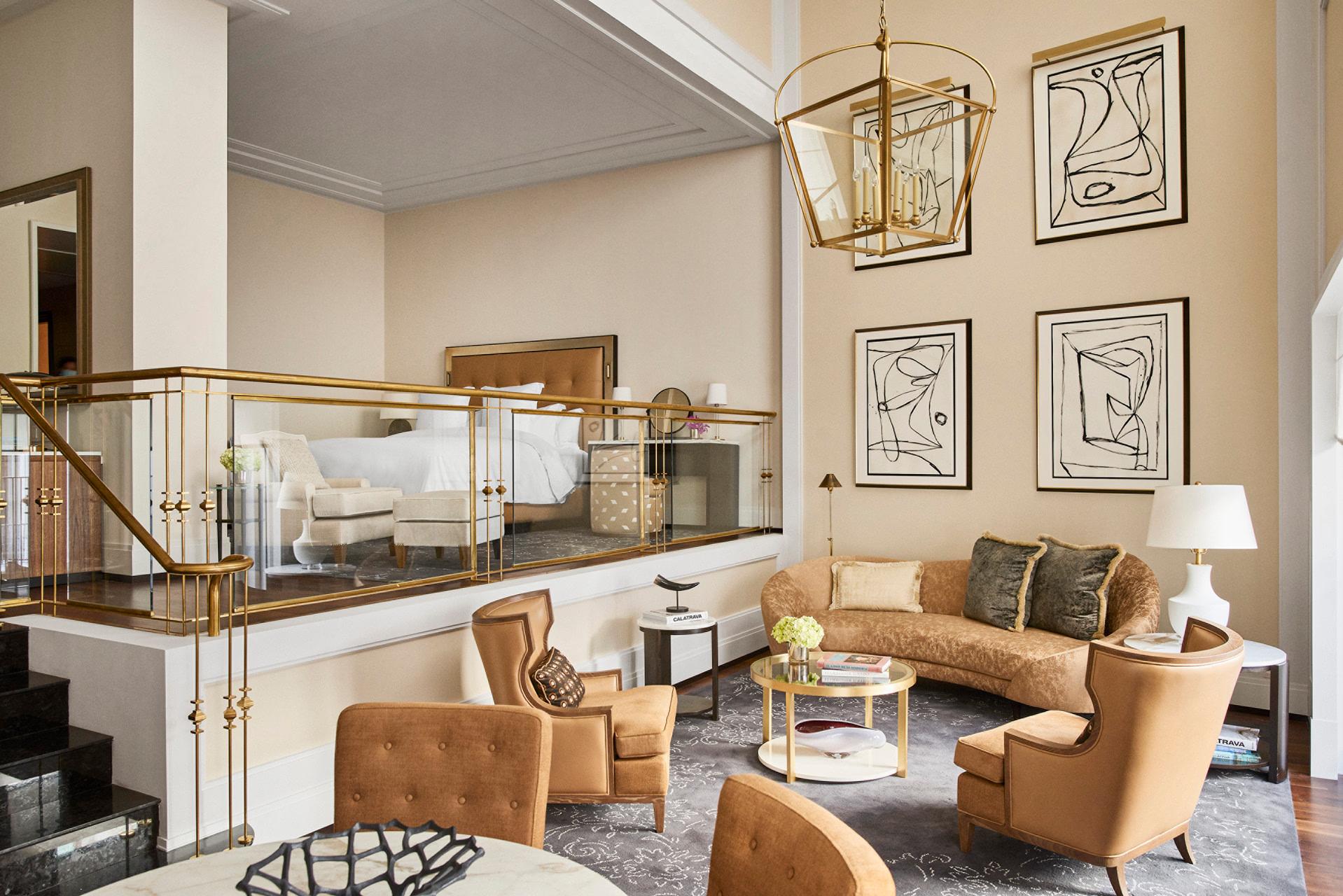 Four Seasons Hotel Madrid: suite with mezzanine level, tan leather seating, glass railings, and artwork on walls
