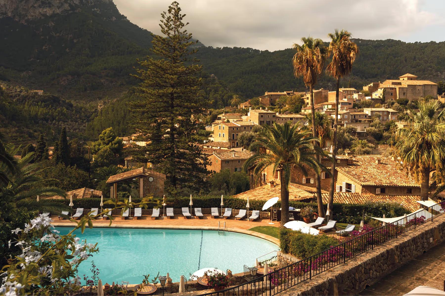La Residencia: resort pool and buildings set in hillside with lounge chairs and Mediterranean backdrop