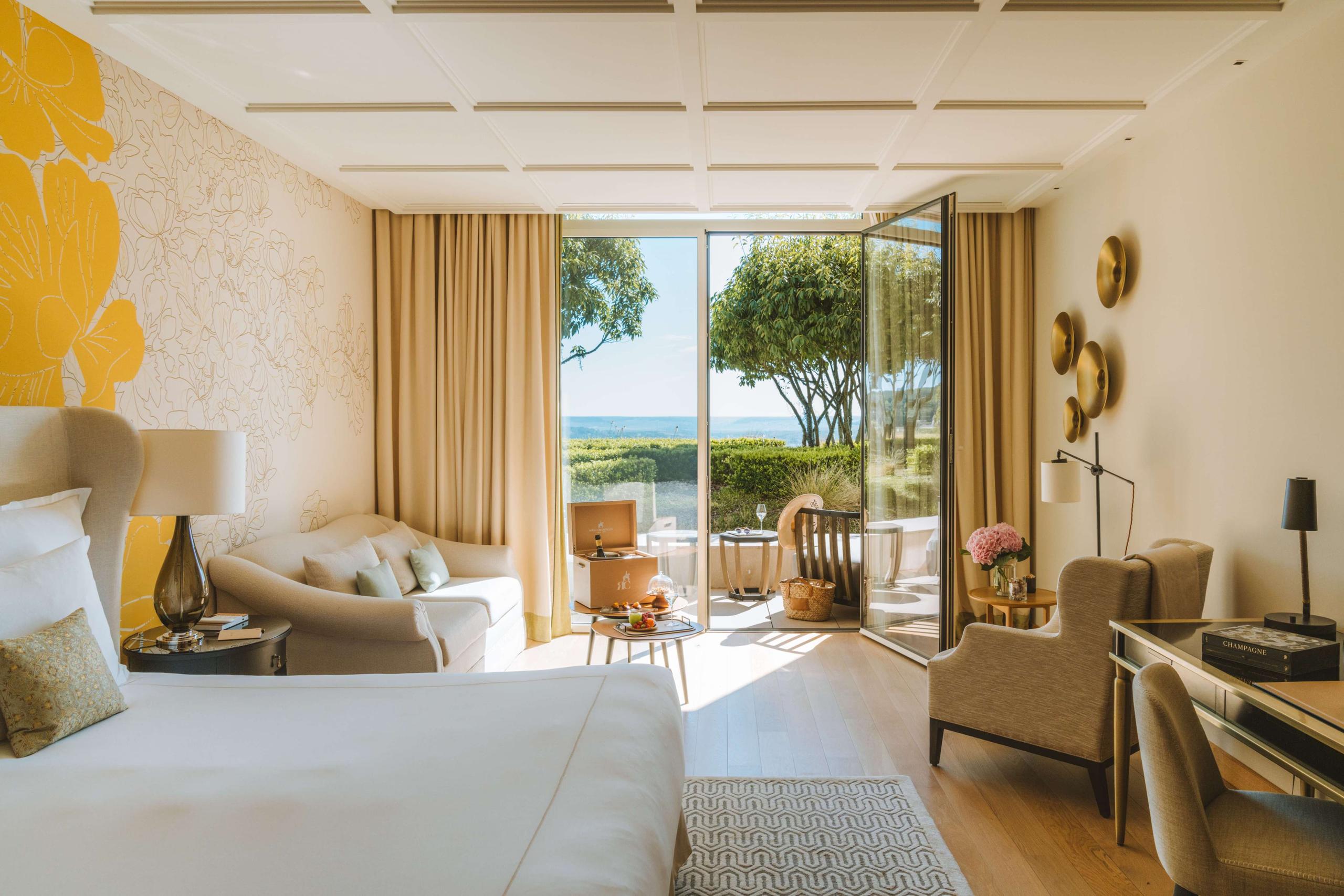 Royal Champagne Hotel & Spa: modern suite with cream furnishings and glass doors opening to a terrace with valley views